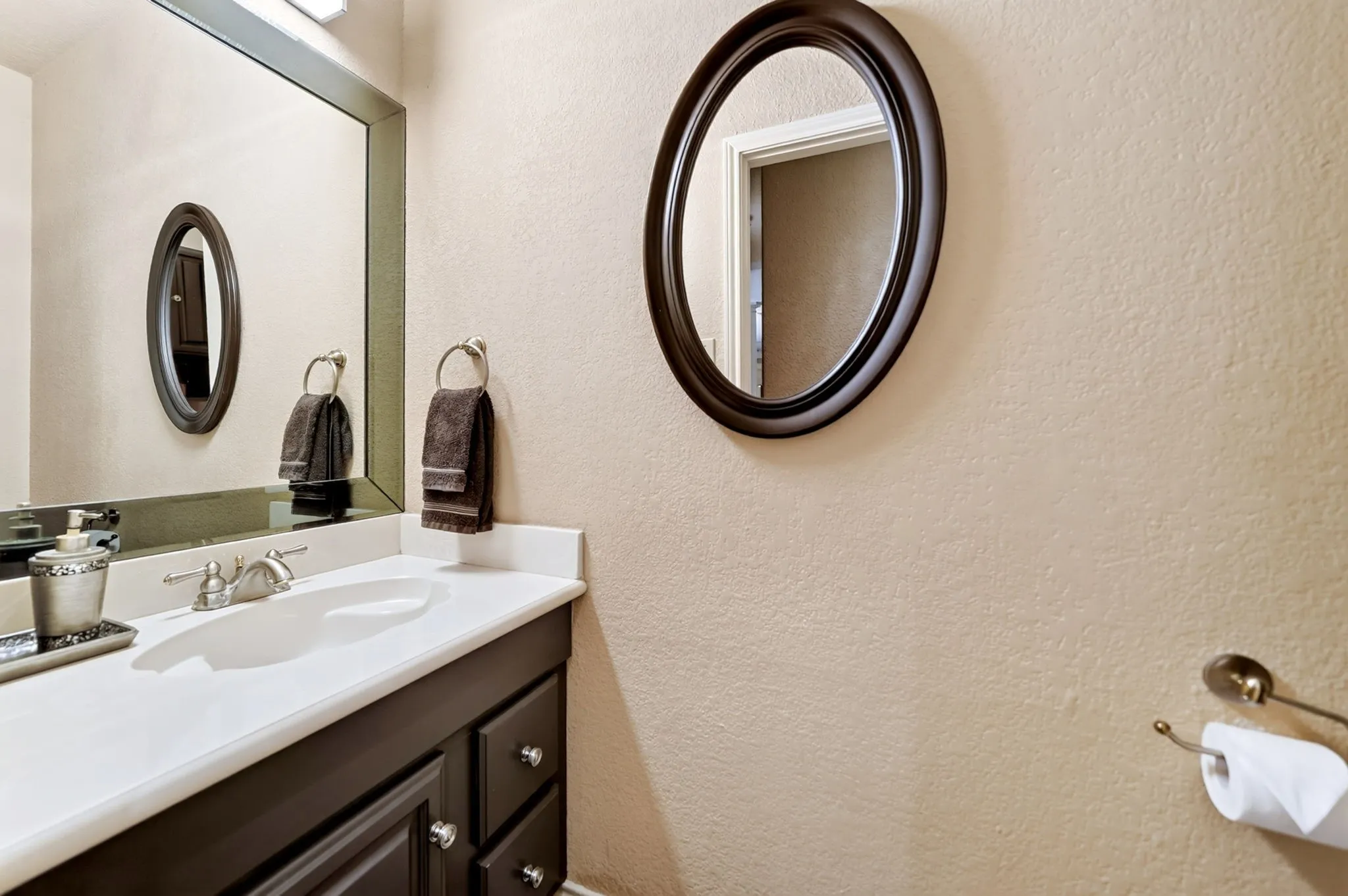 Half bath with vanity featuring a white countertop, undermount sink, and brushed nickel faucet