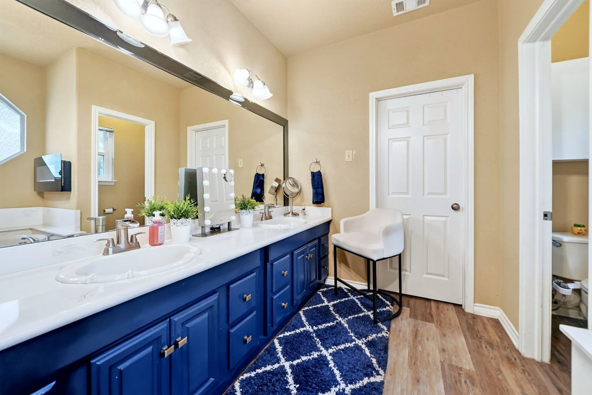 Dual vanity with white undermount sinks, satin nickel faucets, and navy blue cabinetry