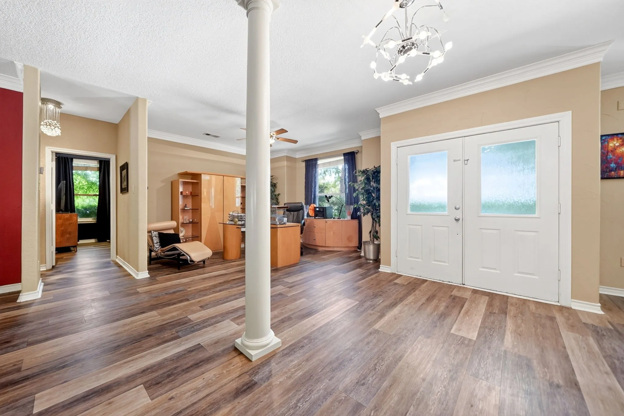 Entryway featuring double doors with frosted glass, wood-finish flooring, a decorative column, and crown molding