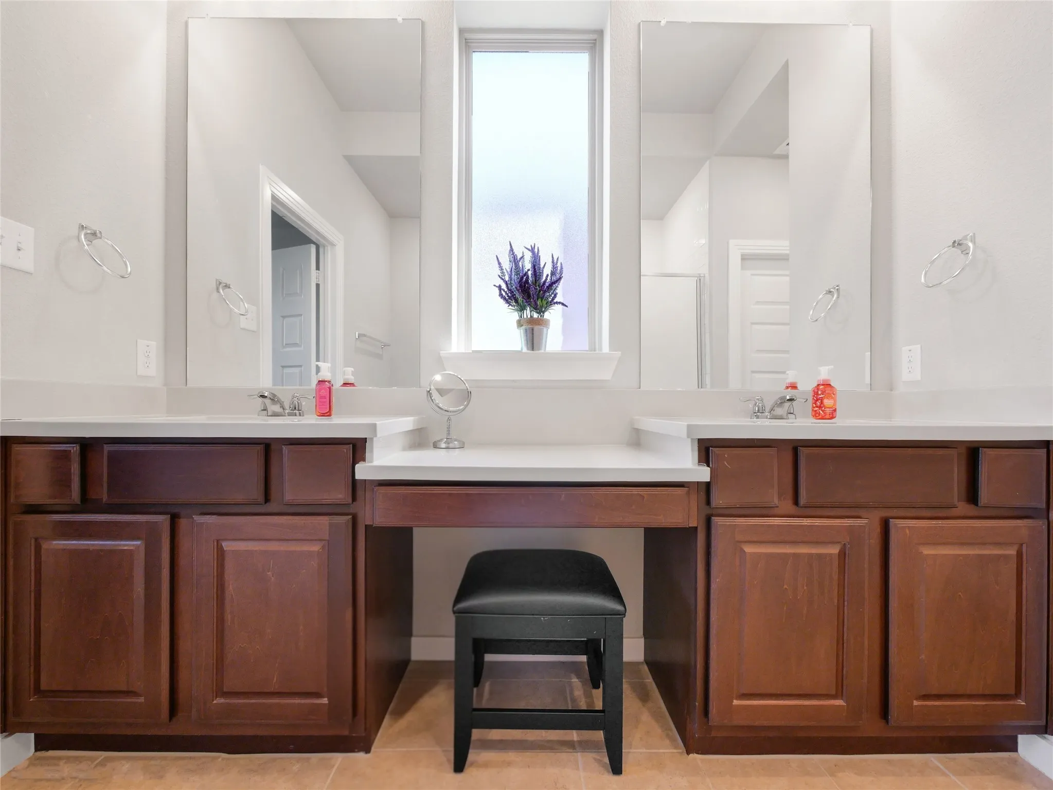 Double vanity featuring dark wood-finish cabinetry, light-toned countertops, and individual rectangular sinks