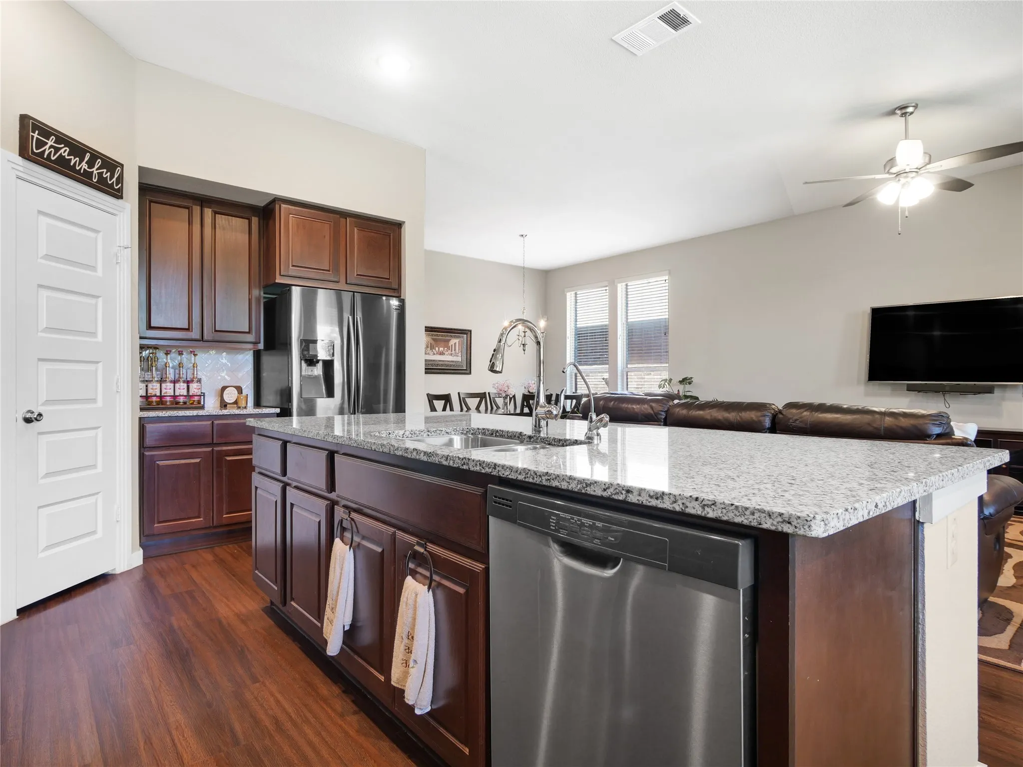Kitchen island featuring a stainless steel sink, gooseneck faucet, and integrated dishwasher