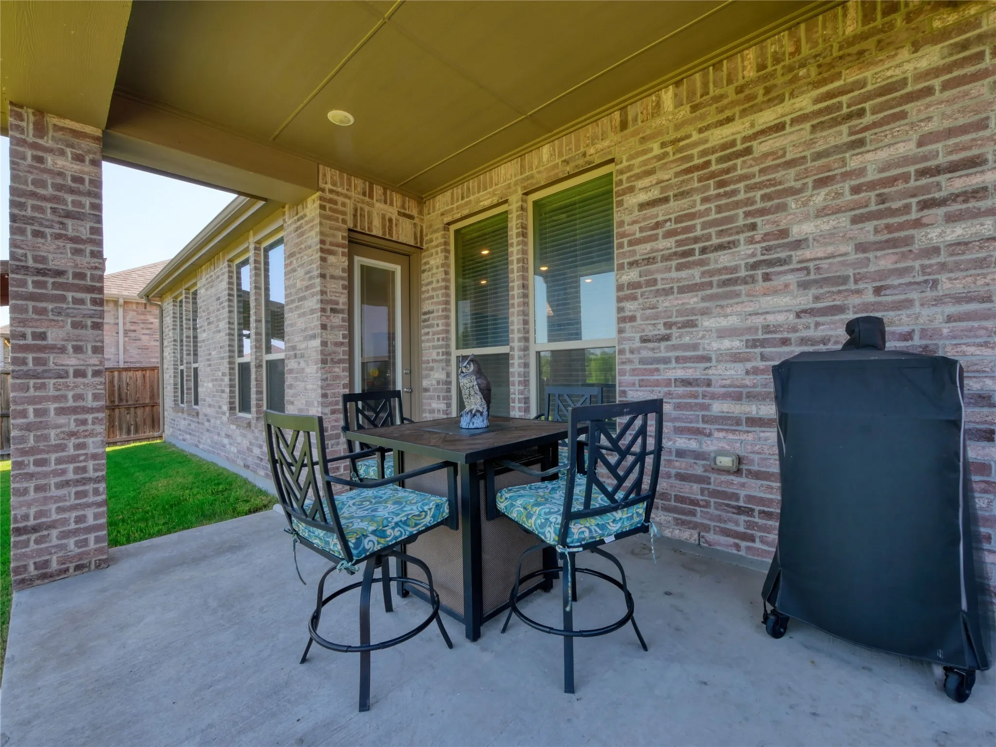 Covered patio featuring a concrete slab and brick exterior