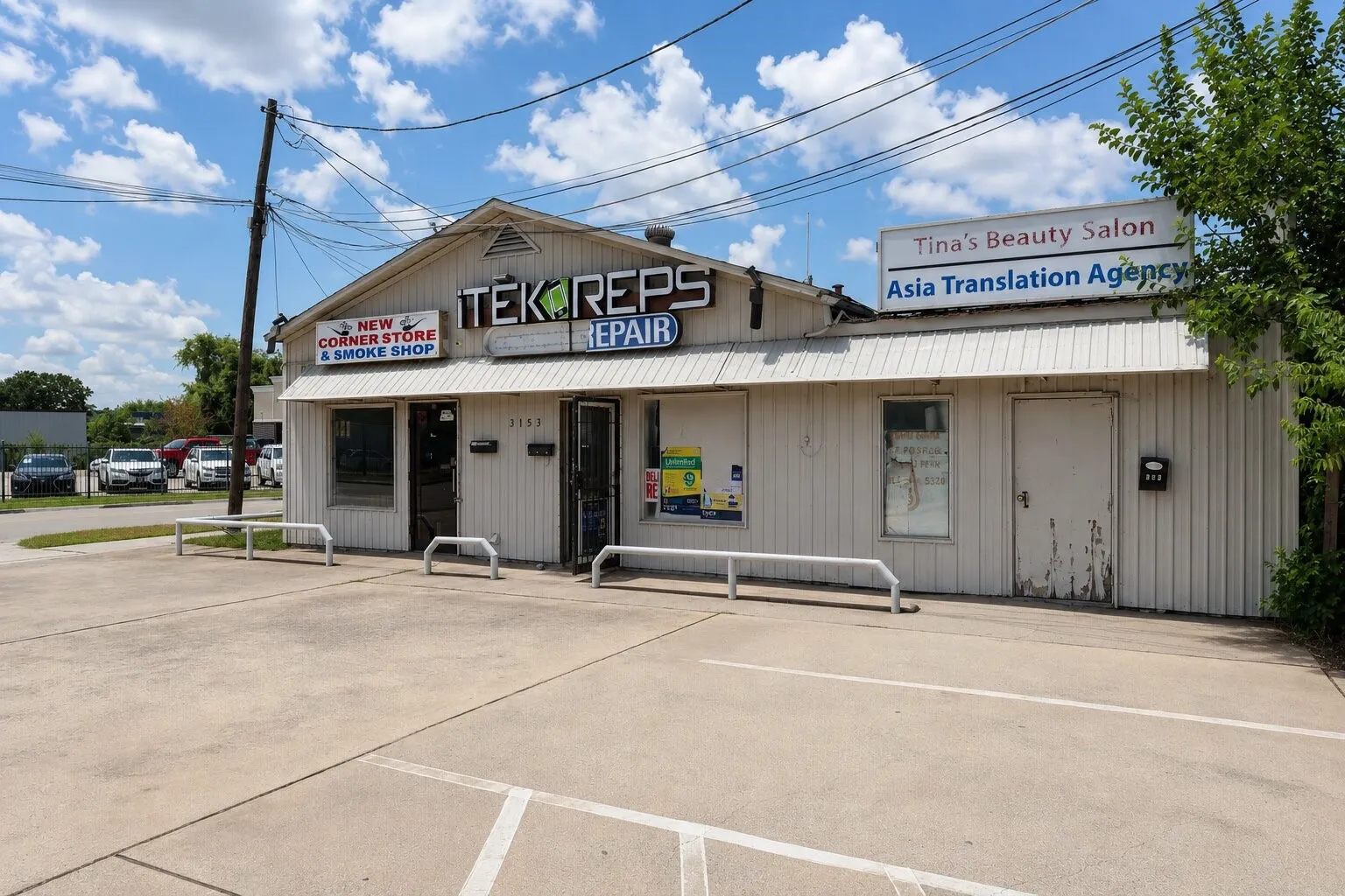 Commercial building with a gable roofline, featuring multiple storefront entrances and exterior signage