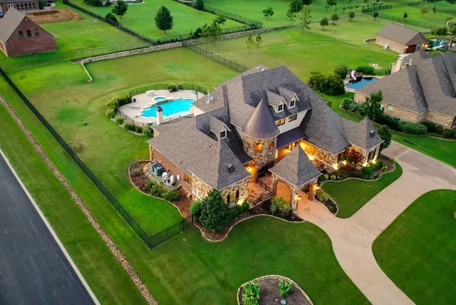 Stone and brick exterior residence featuring a multi-gabled roofline, turret, and dormer windows
