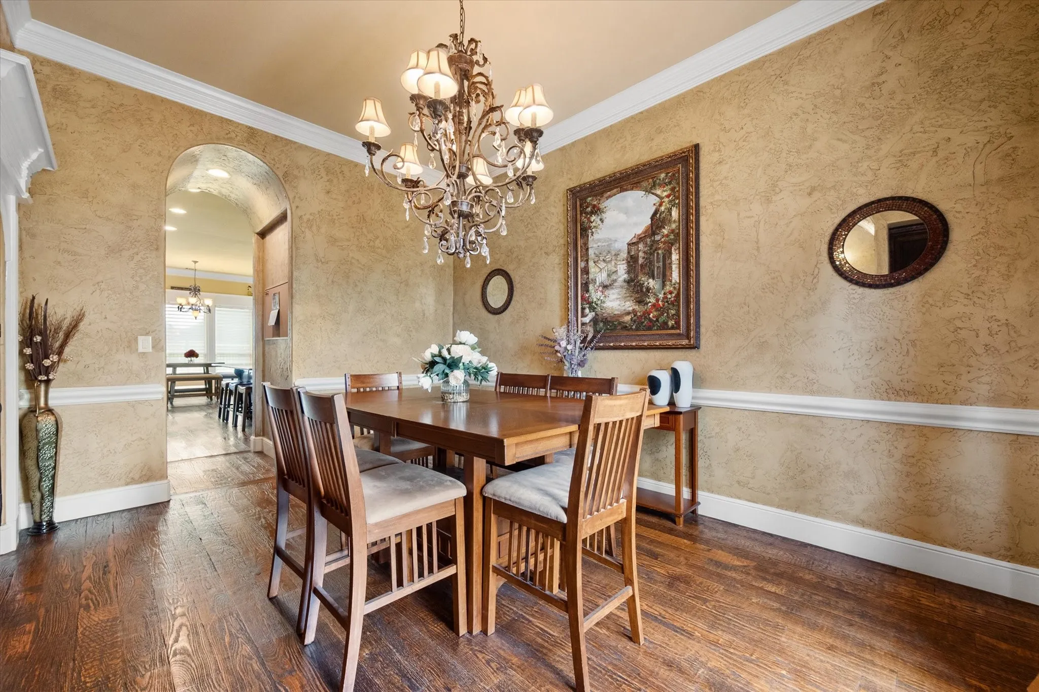 Formal dining area featuring textured wall finish and dark wood-finish flooring