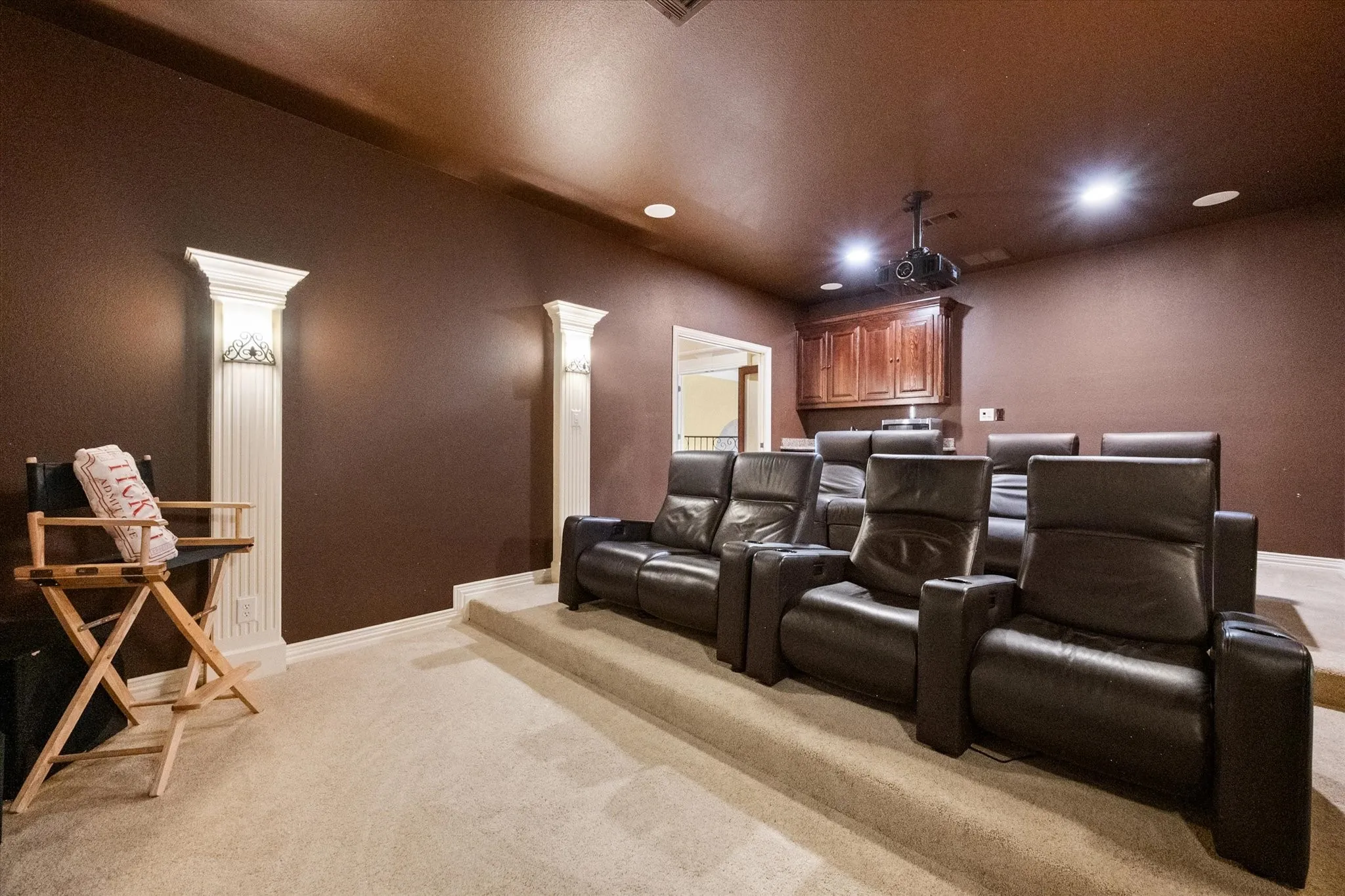 Dedicated media room featuring tiered seating platforms and recessed lighting