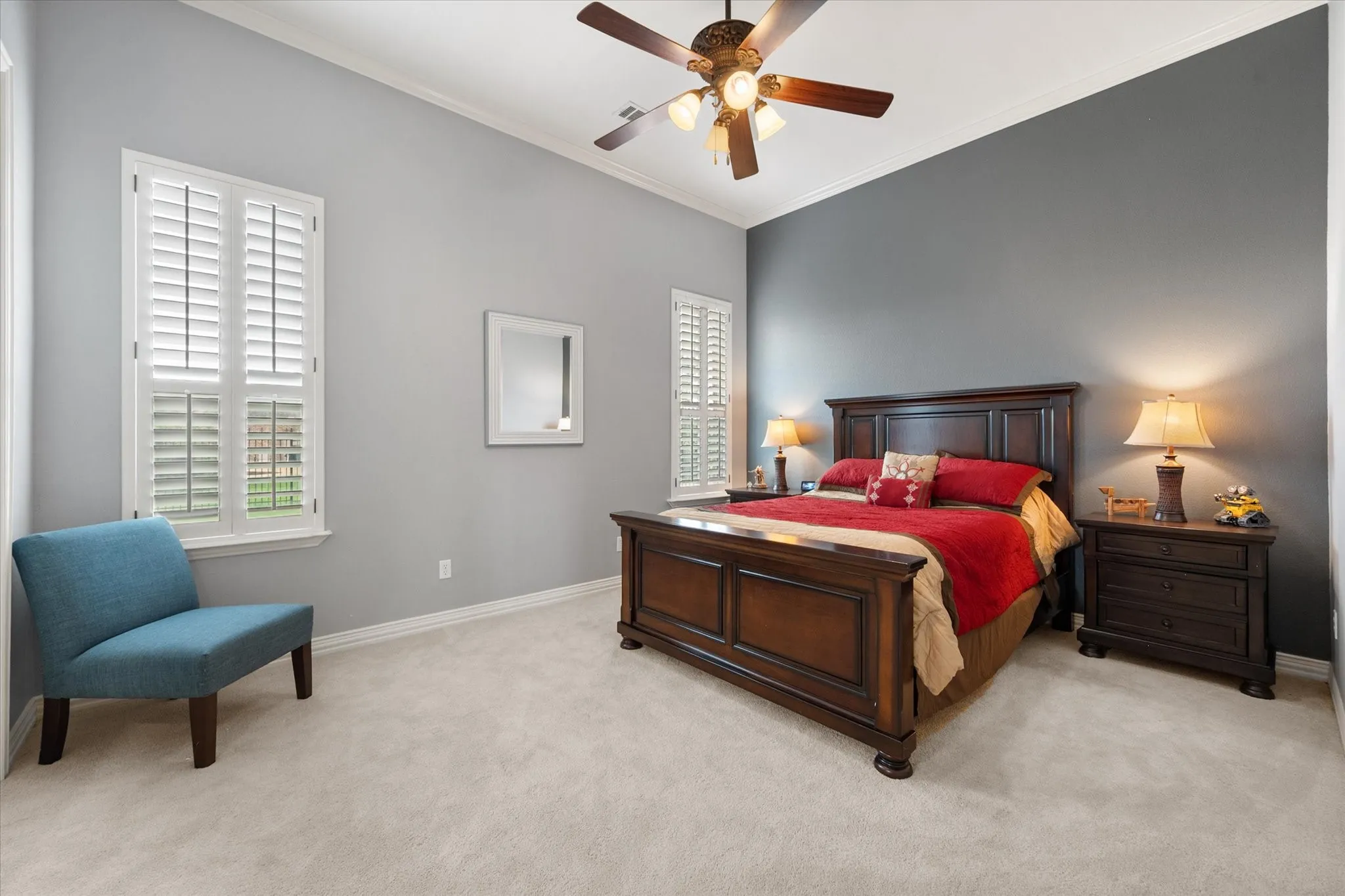 First floor bedroom featuring an accent wall, vaulted ceiling, and plush carpeting