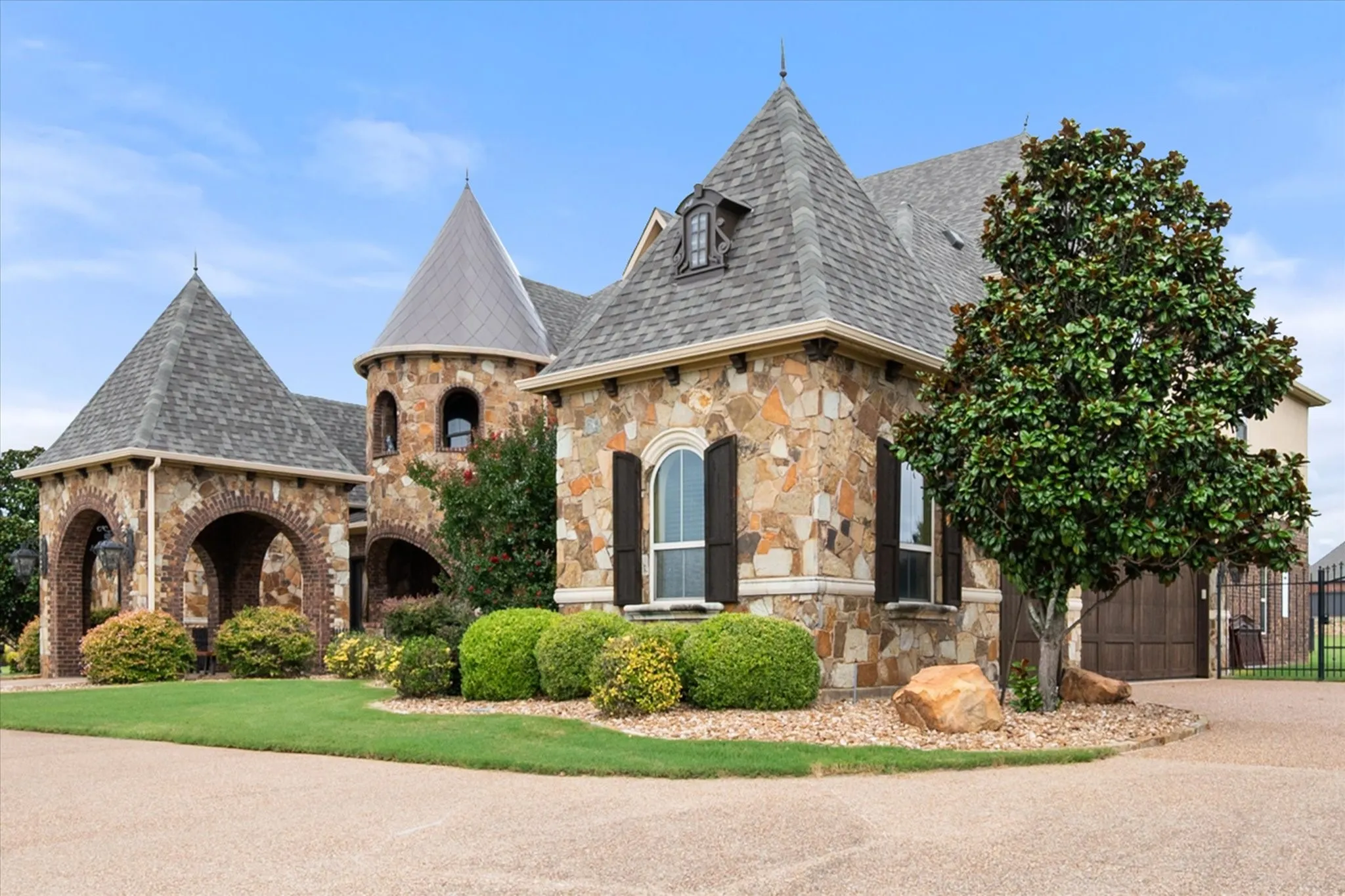 Stone facade home featuring multiple turrets with conical roofs and dormer windows