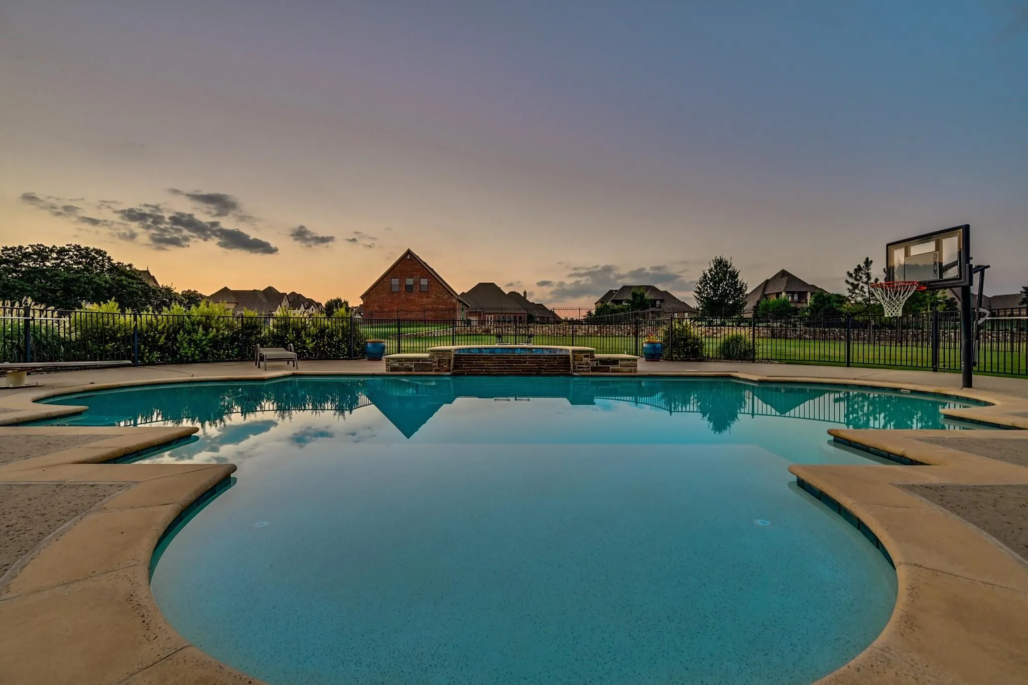 Freeform swimming pool with integrated spa and stone surround