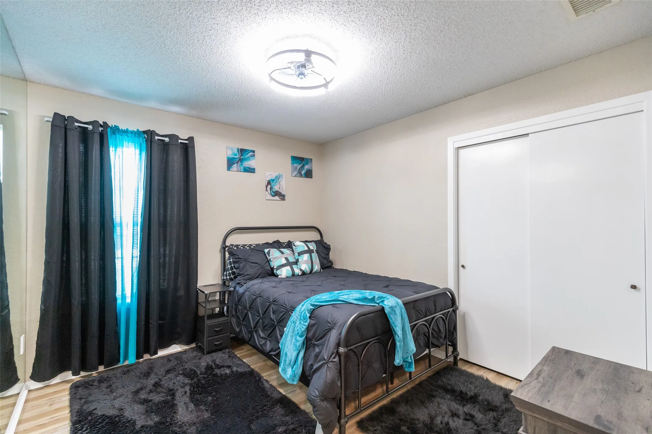 Bedroom2  featuring wood-finish flooring, a contemporary ceiling light fixture, and a full-length mirrored wall