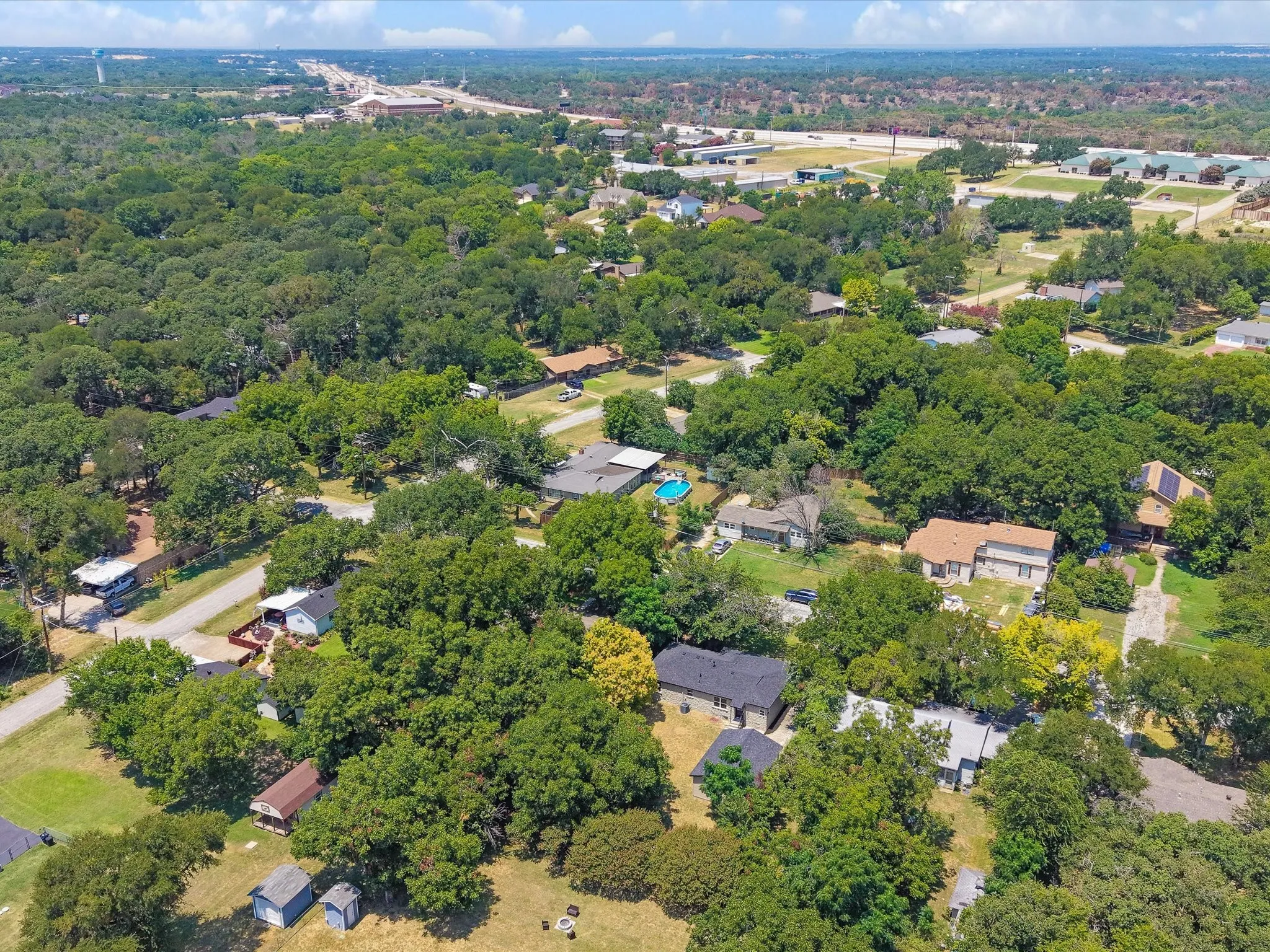 Aerial perspective of a residential area characterized by abundant mature trees and varied architectural styles