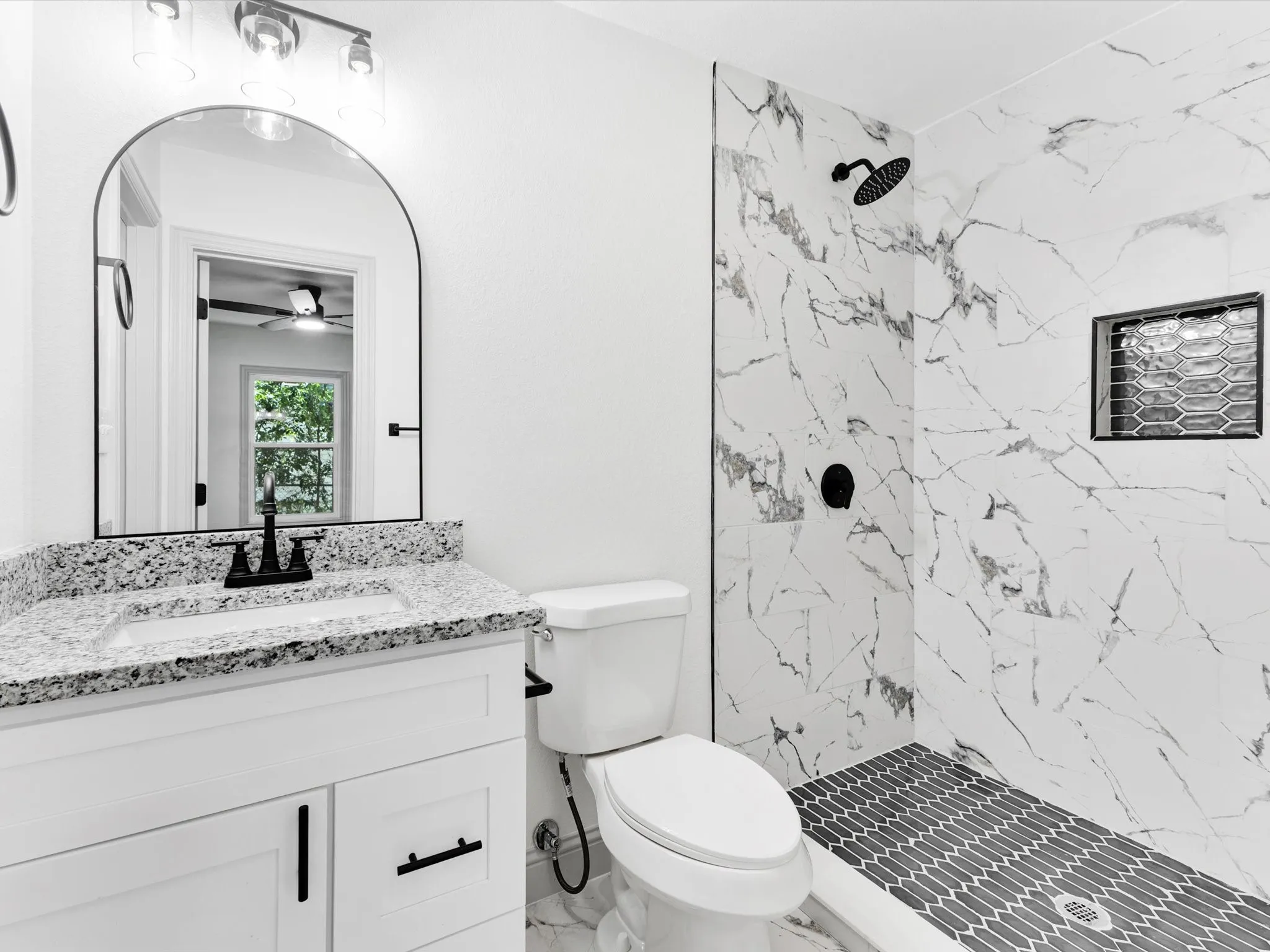 Contemporary bathroom featuring a white vanity with a granite countertop, undermount sink, and matte black faucet