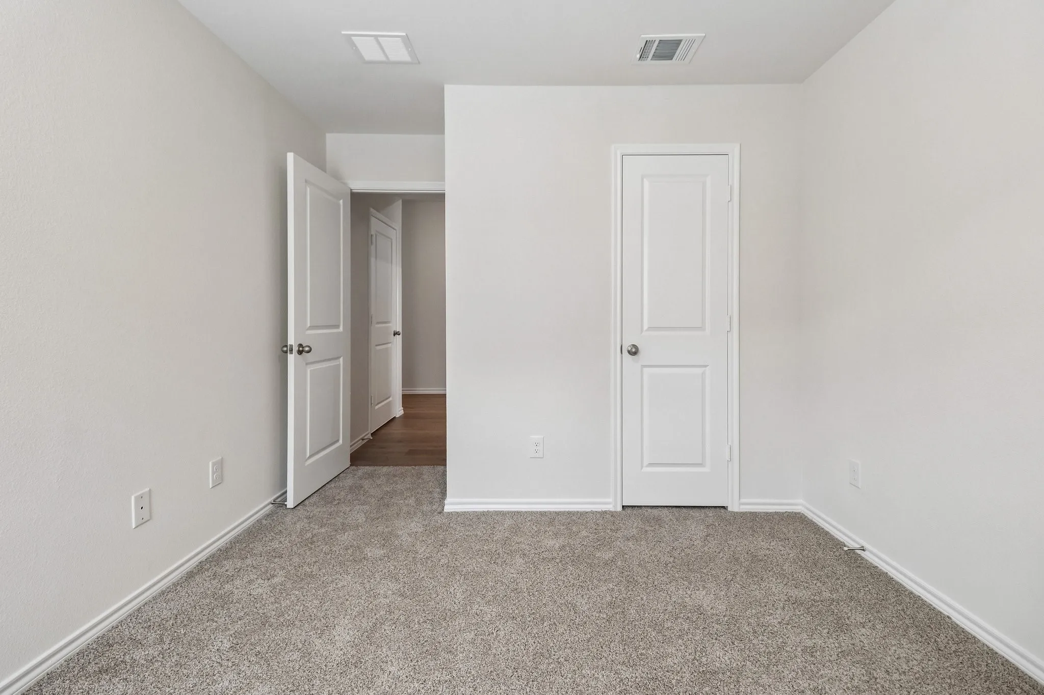 Carpeted interior room with white walls and trim