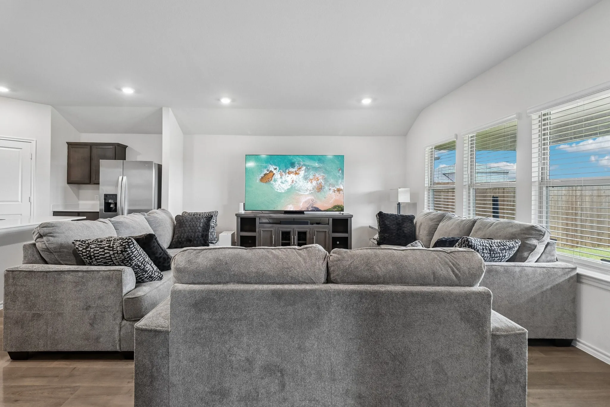 Spacious living area featuring wood-finish flooring and recessed lighting