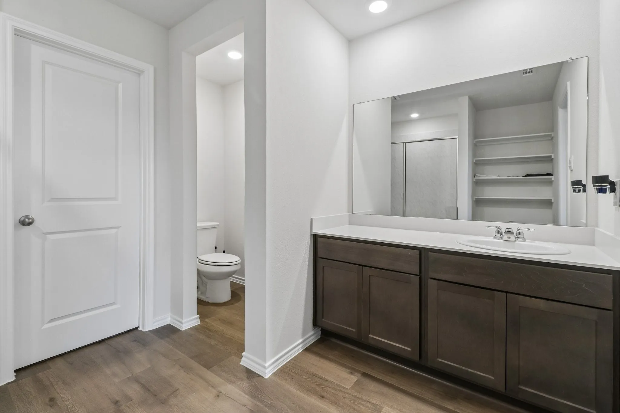 Spacious vanity with dark wood-finish cabinetry and a light-toned countertop