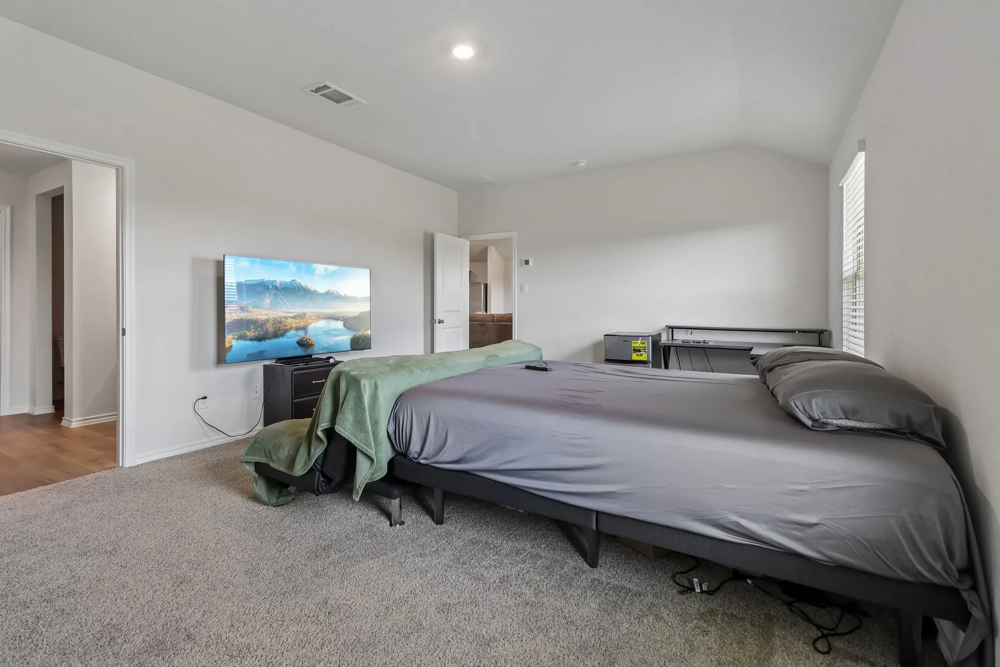 Carpeted room featuring a single window with blinds, recessed lighting, and white baseboards