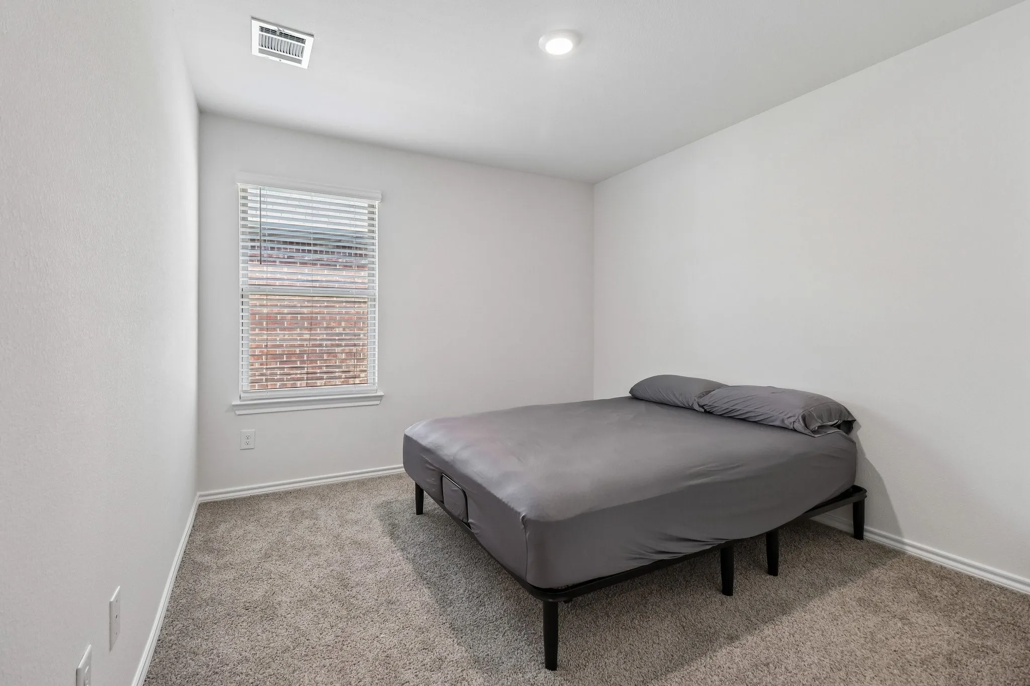 Carpeted room featuring a single window with blinds, recessed ceiling lighting, and a ceiling-mounted ventilation register