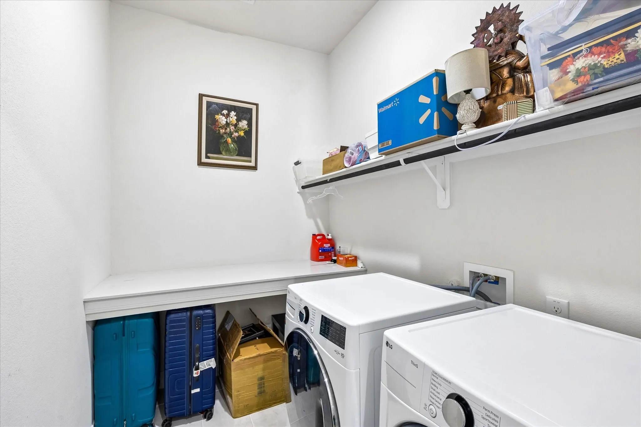 Dedicated laundry area featuring white walls, an integrated countertop, and built-in shelving