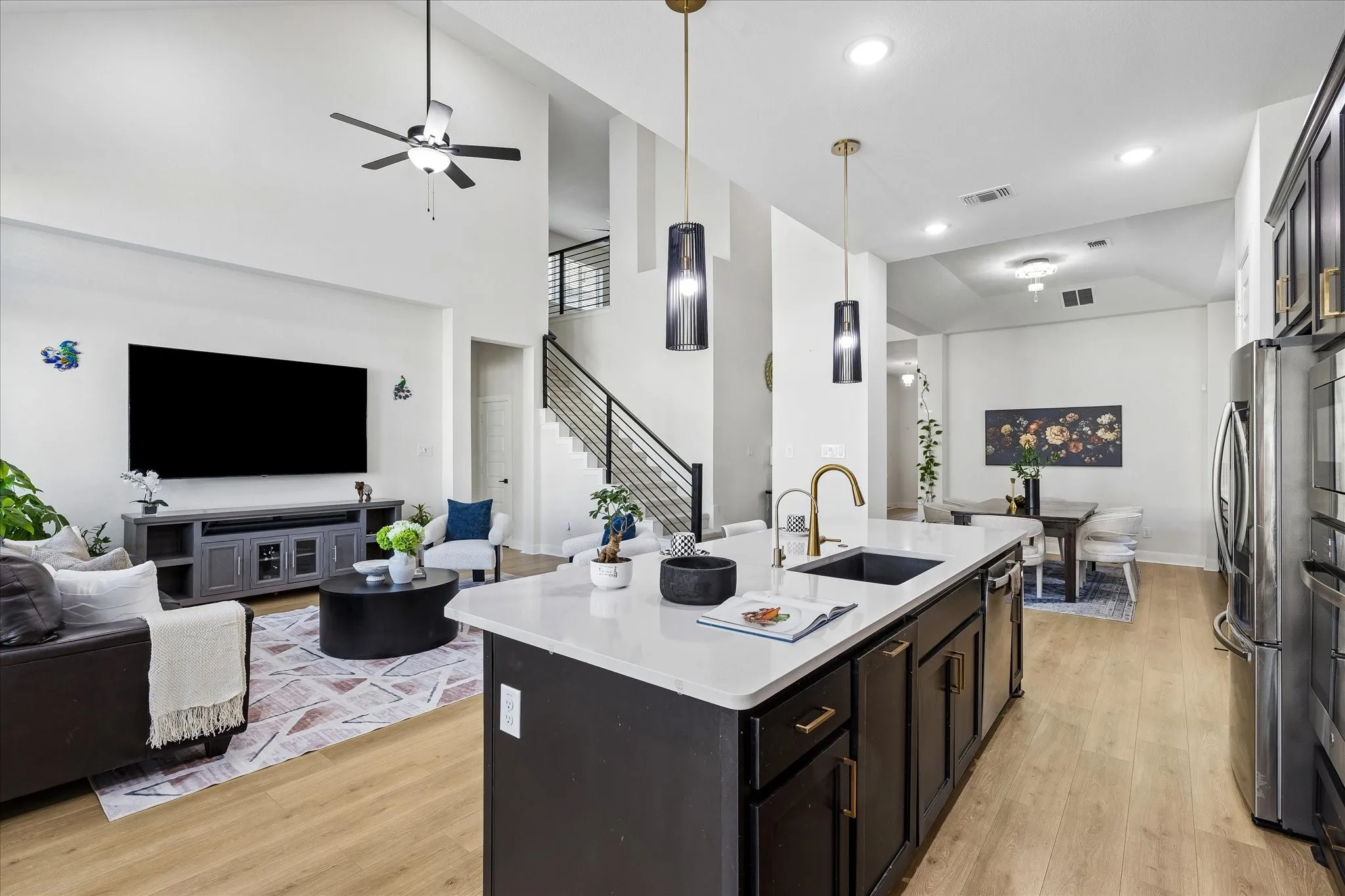 Open-concept living space featuring a modern kitchen island with white countertop, recessed lighting, and wood-finish flooring