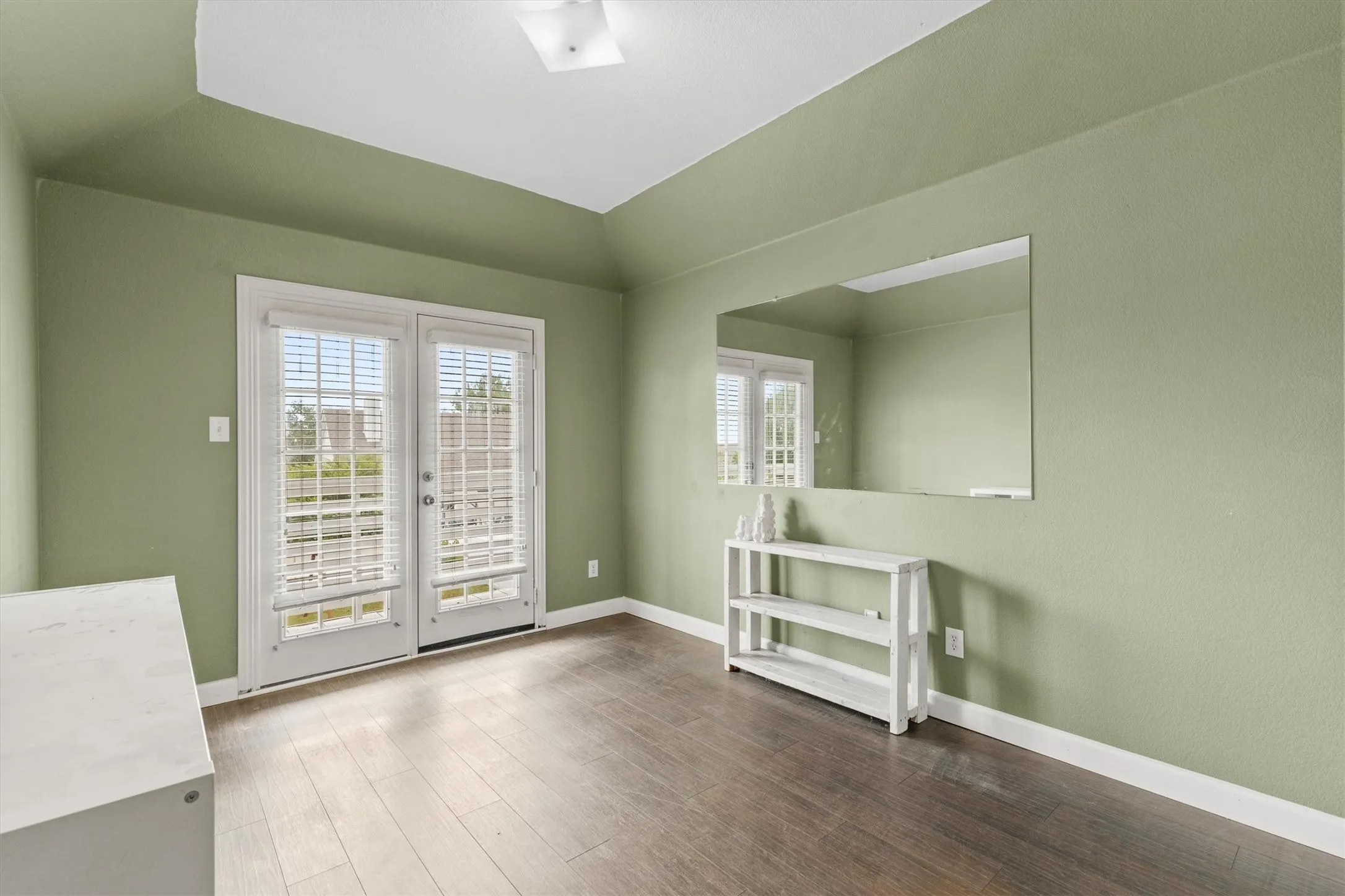 Large bedroom with wood-finish flooring and walk-in closet