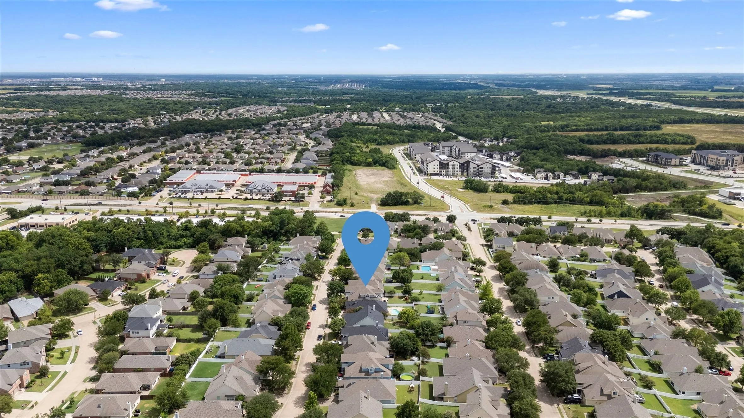 Aerial perspective showcasing a residential neighborhood with mature trees and a manicured streetscape