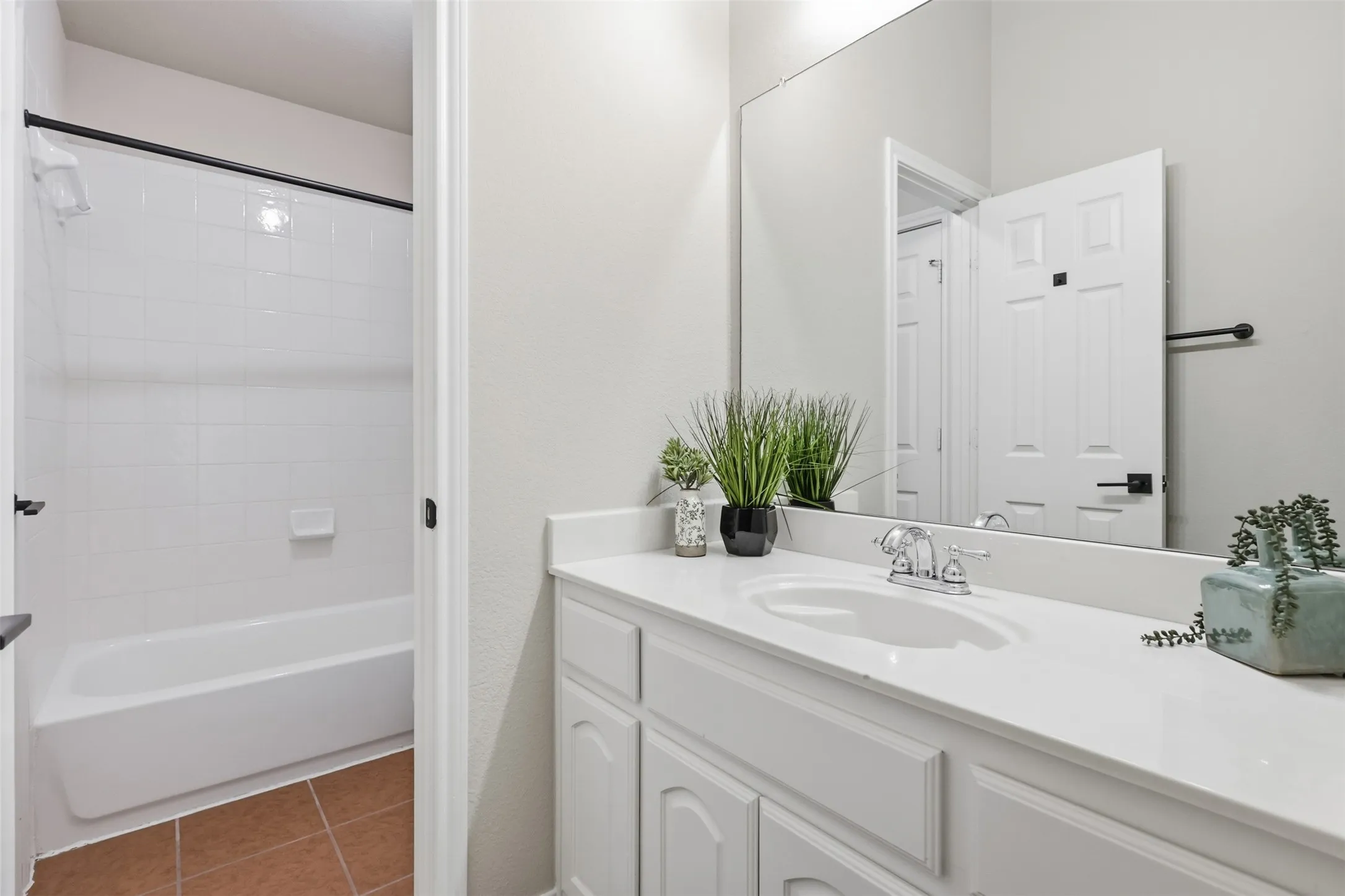 Jack and Jill Bathroom featuring a secondary white vanity with integrated sink, chrome faucet, and a large wall mirror.