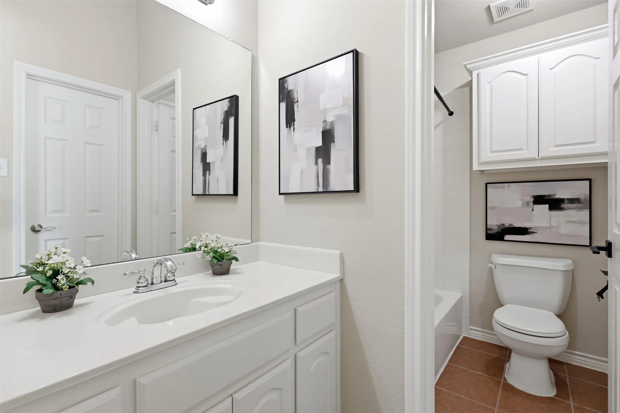 Jack and Jill Bathroom featuring a vanity with integrated sink with chrome faucet, white countertop, and white cabinetry.