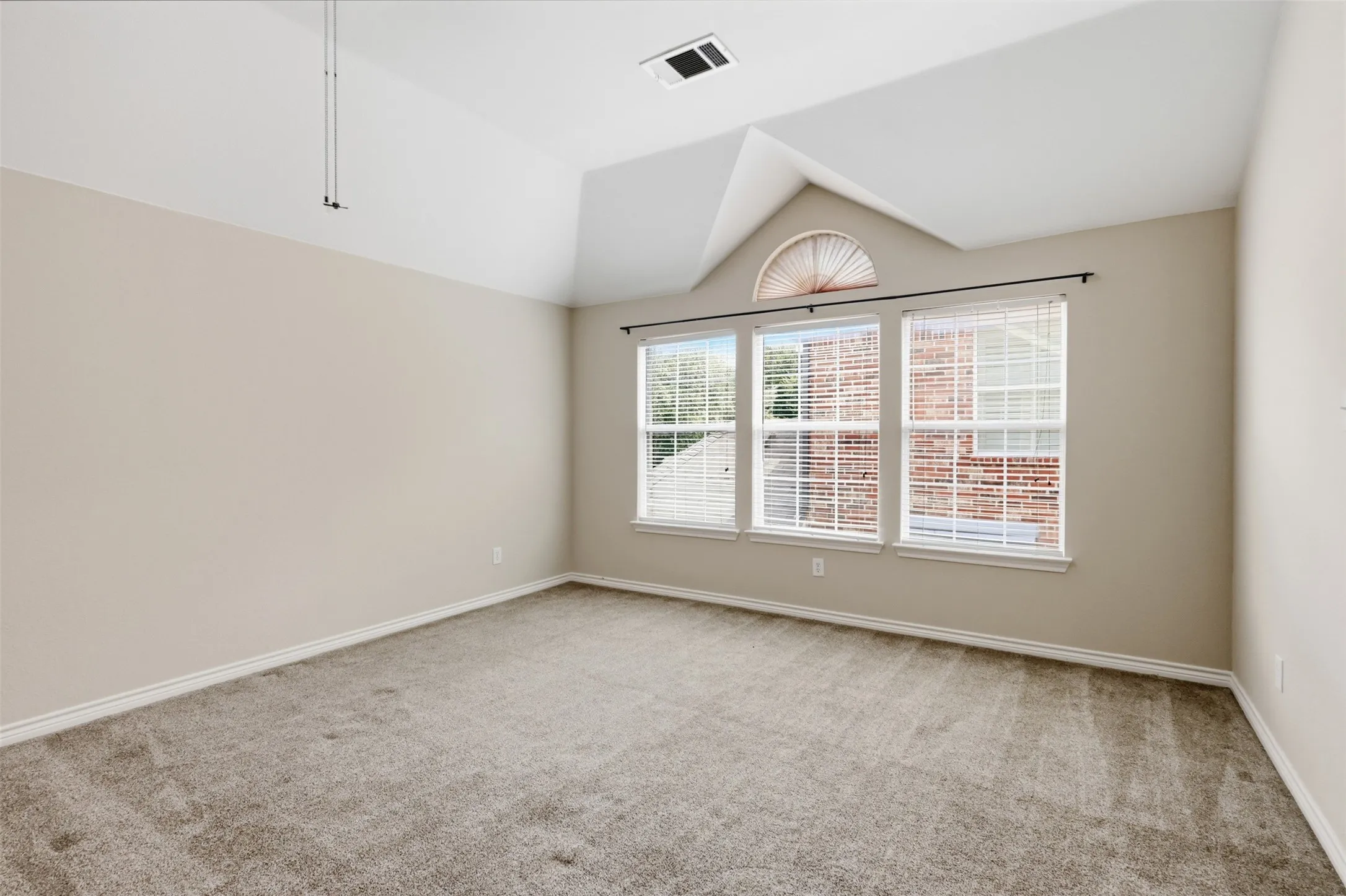 Loft area  with plush carpeting, large window with blinds and ceiling fan.