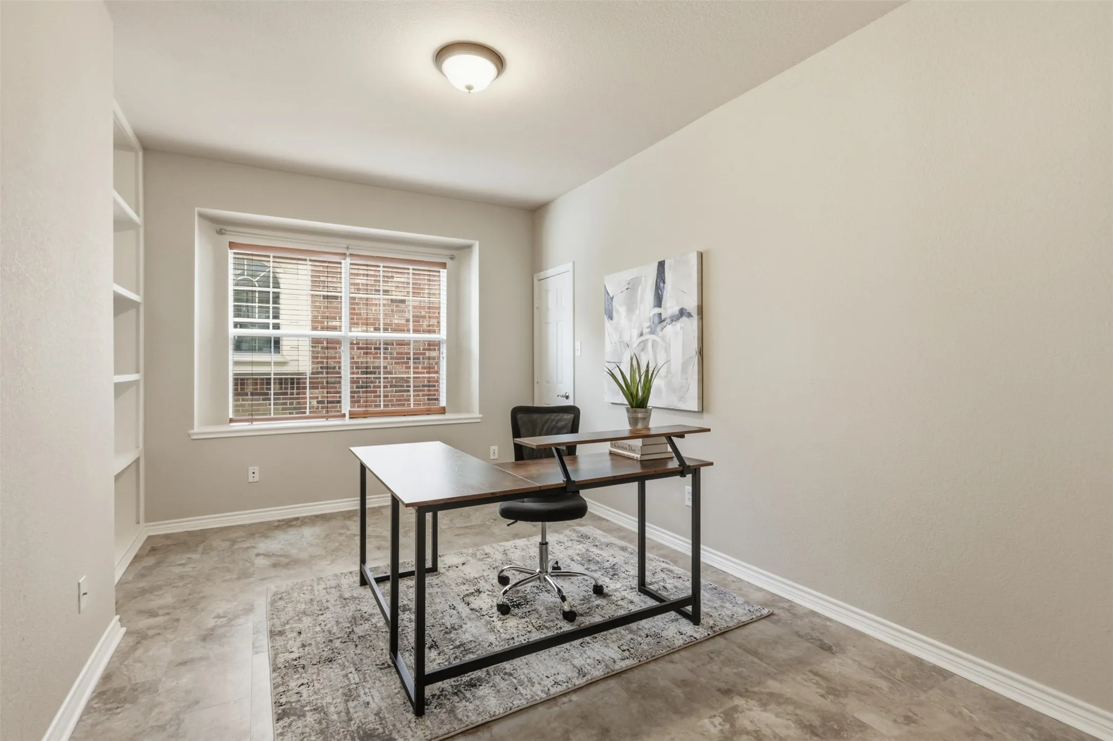 Expansive room featuring tile flooring, a large window with blinds, and built-in shelving.