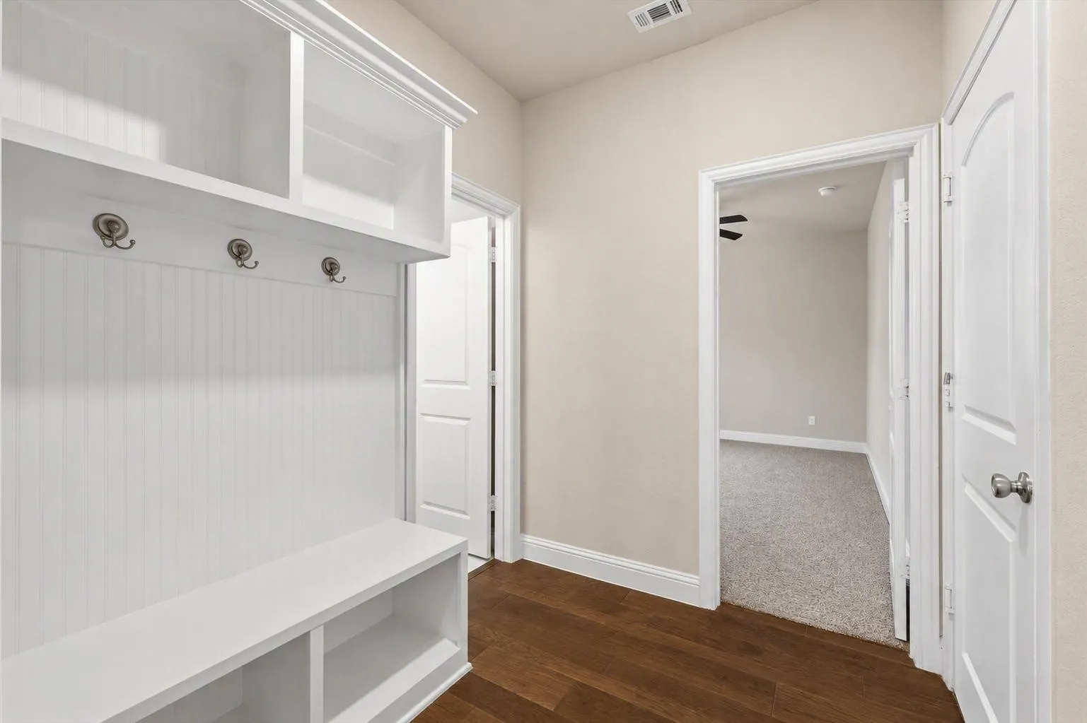 Built-in mudroom bench with cubby storage, beadboard backing, and brushed nickel hooks