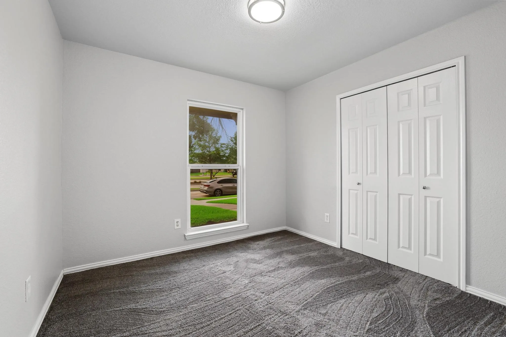 Neutral wall paint finishes, textured gray carpet, and white bi-fold closet doors
