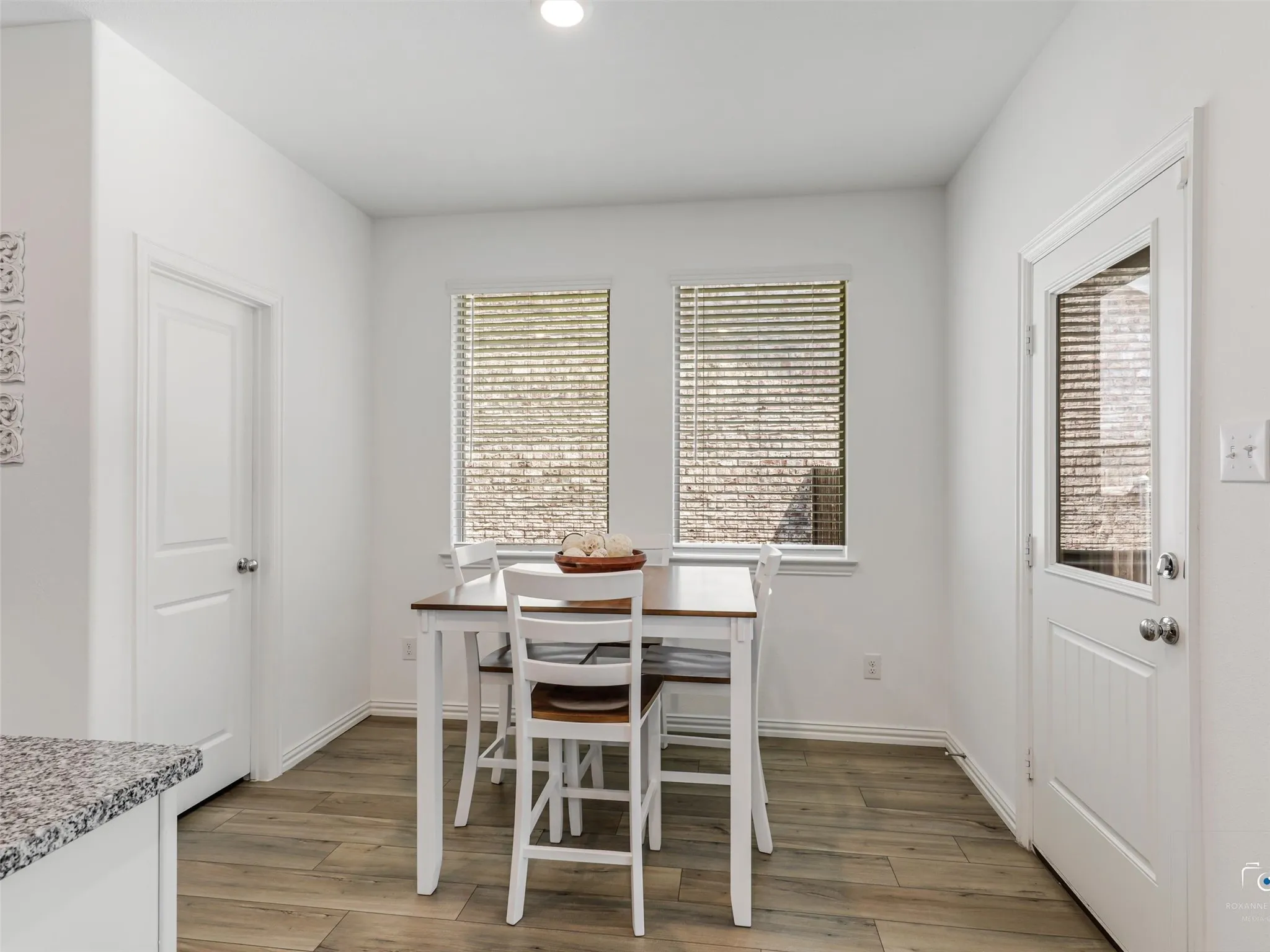 This breakfast nook is located adjacent to the kitchen. The door on the right leads to the backyard. A storm/screen door can be found through the back door.