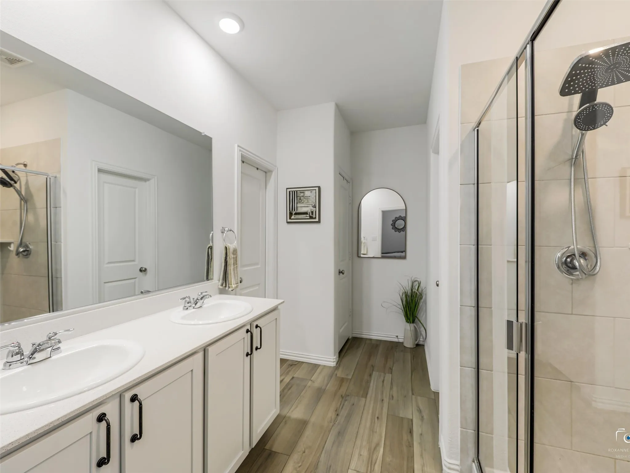 The door to the left of the double vanity leads to the large walk-in closet