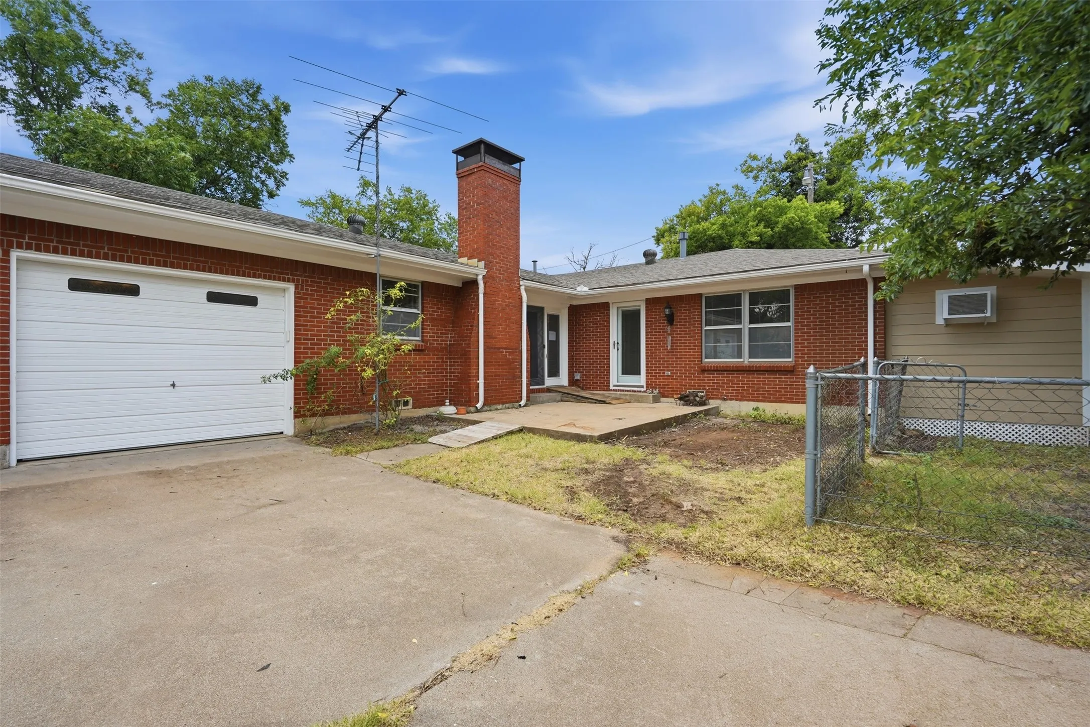 Brick exterior with a white garage door featuring horizontal paneling and rectangular window inserts