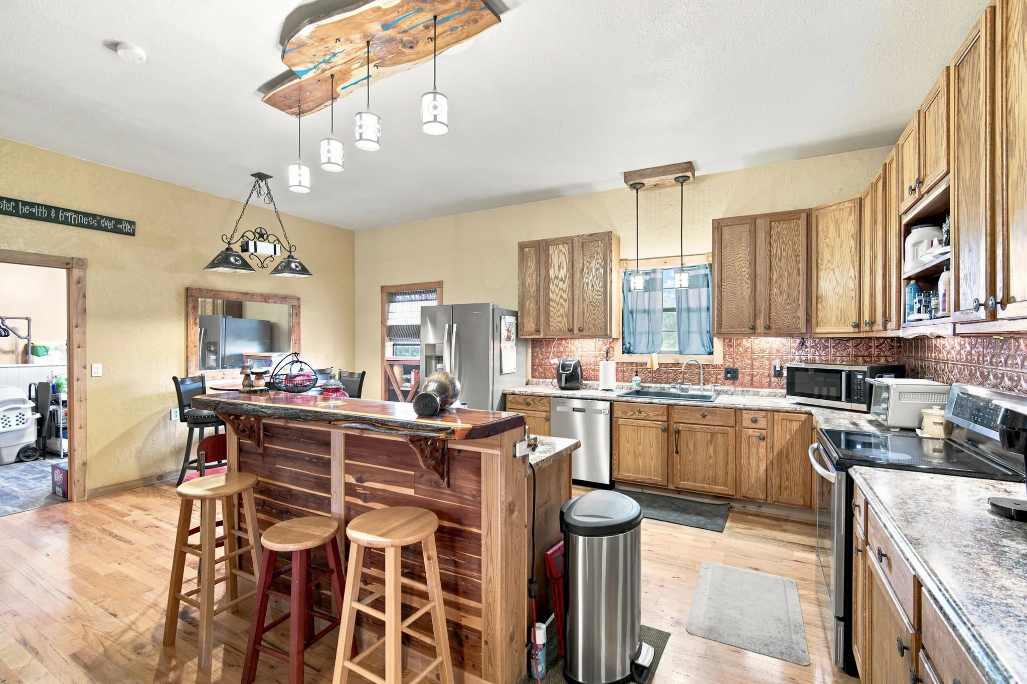 Kitchen features a custom built bar with cedar counter top and front. Notice the custom made light fixture also.  All trim thoughout is cedar.