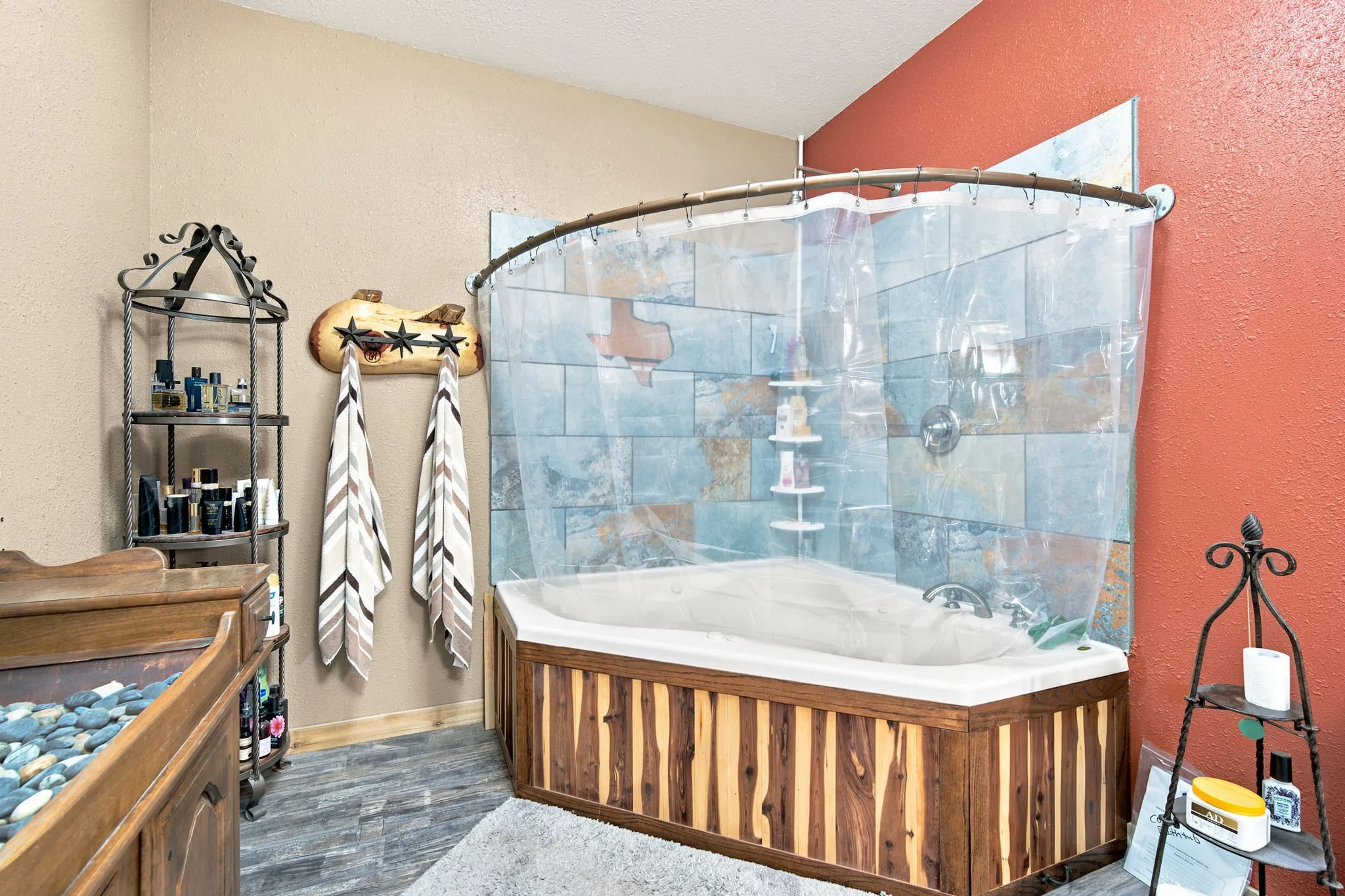 Custom cedar surround on Jacuzzi tub-shower in primary bath. Tile features a Texas shaped mirror.