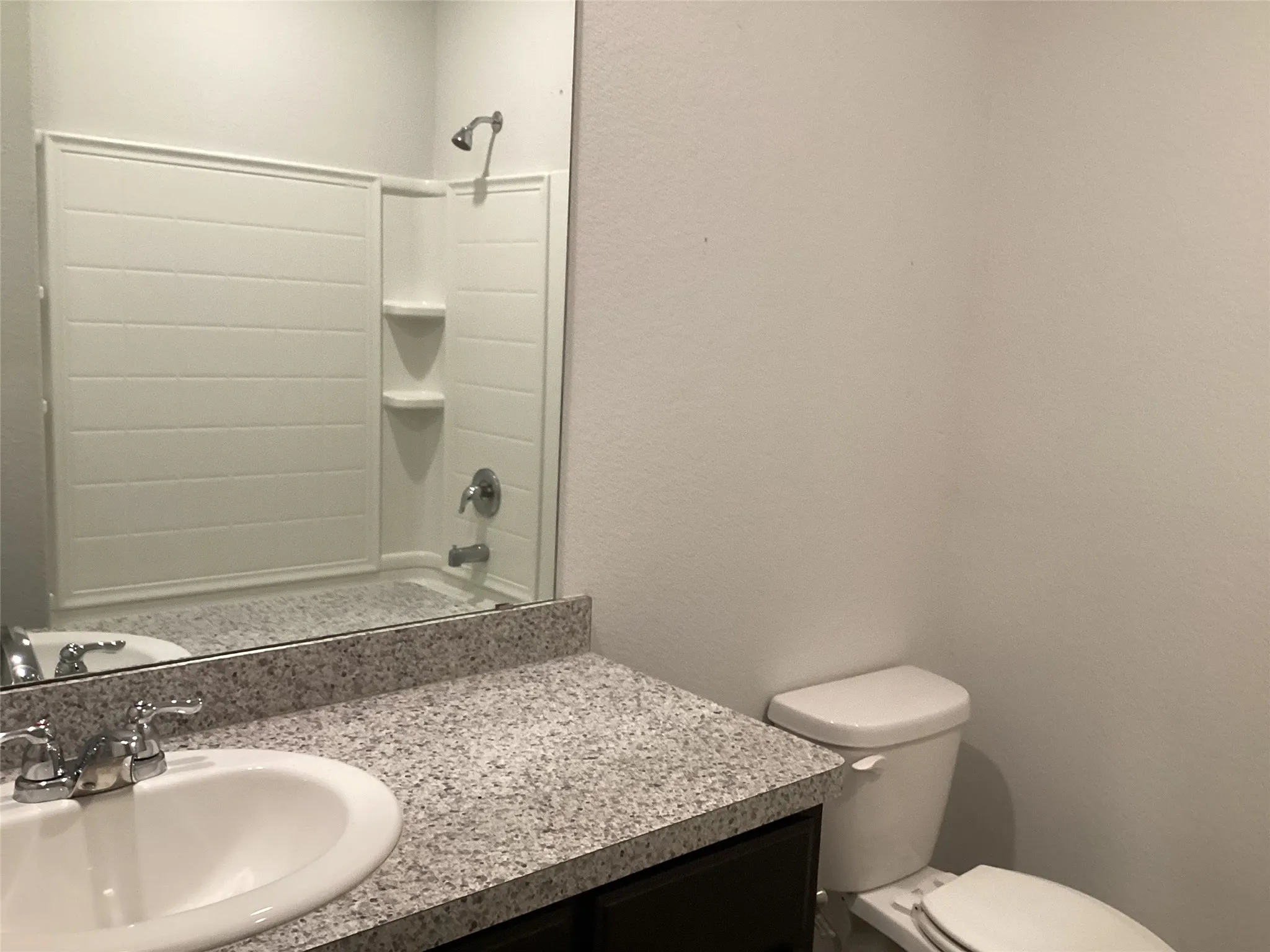 Bathroom featuring a vanity with an integrated sink, granite-patterned countertop, and chrome fixtures
