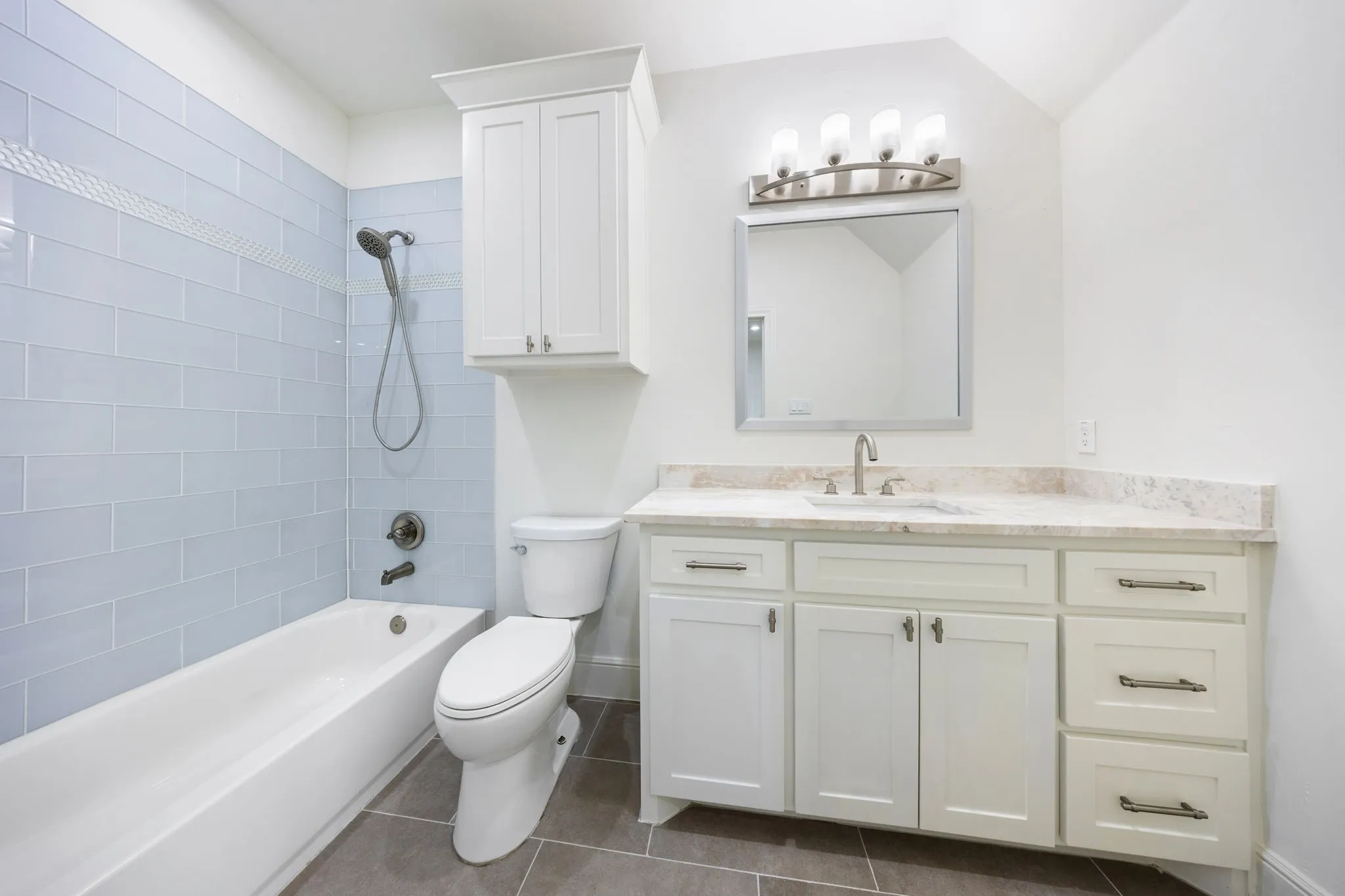Bathroom featuring a white vanity with a stone countertop, a rectangular undermount sink, and a brushed nickel faucet