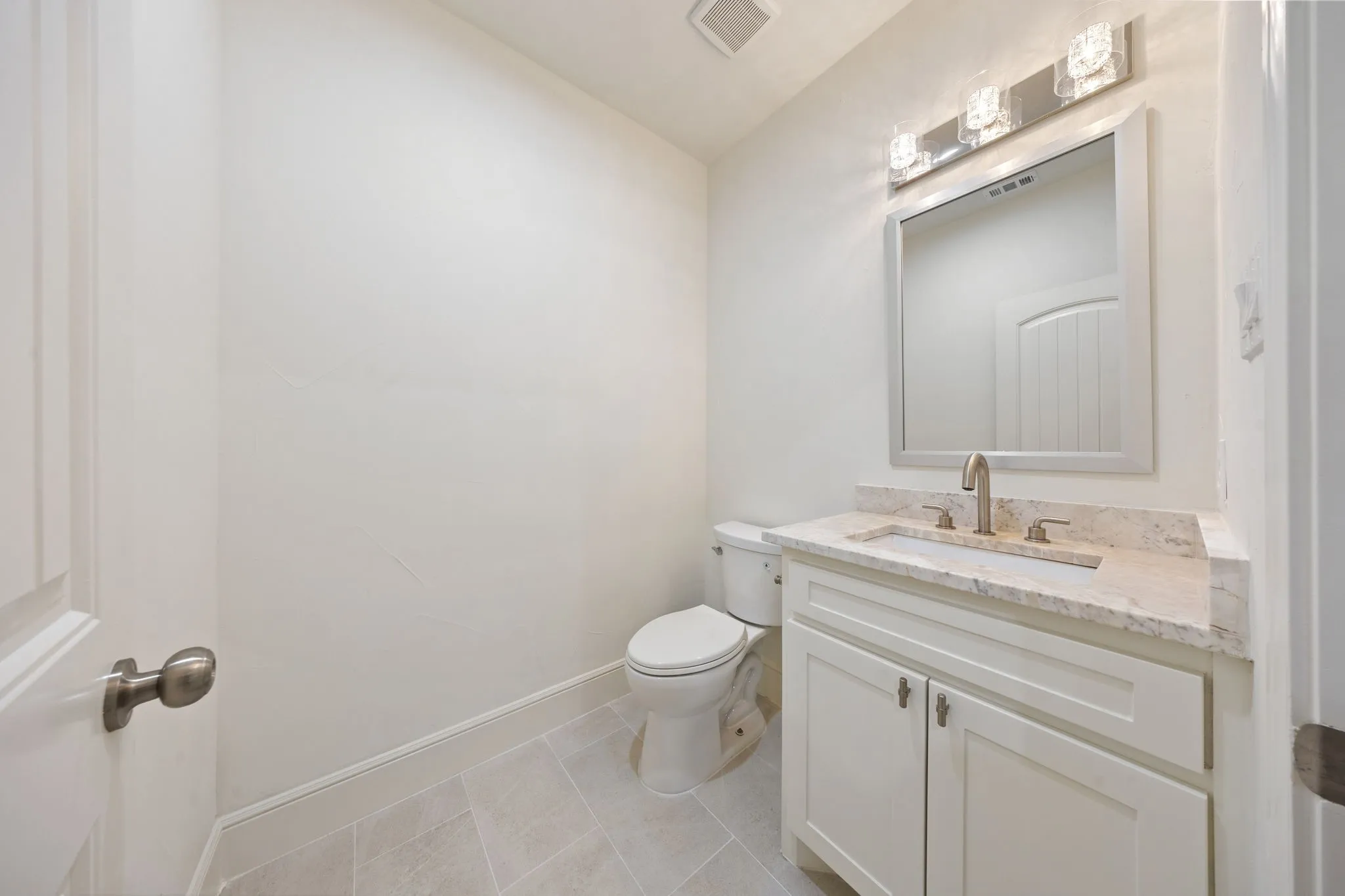 Bathroom featuring a white vanity with a light-toned countertop, undermount sink, and brushed nickel faucet