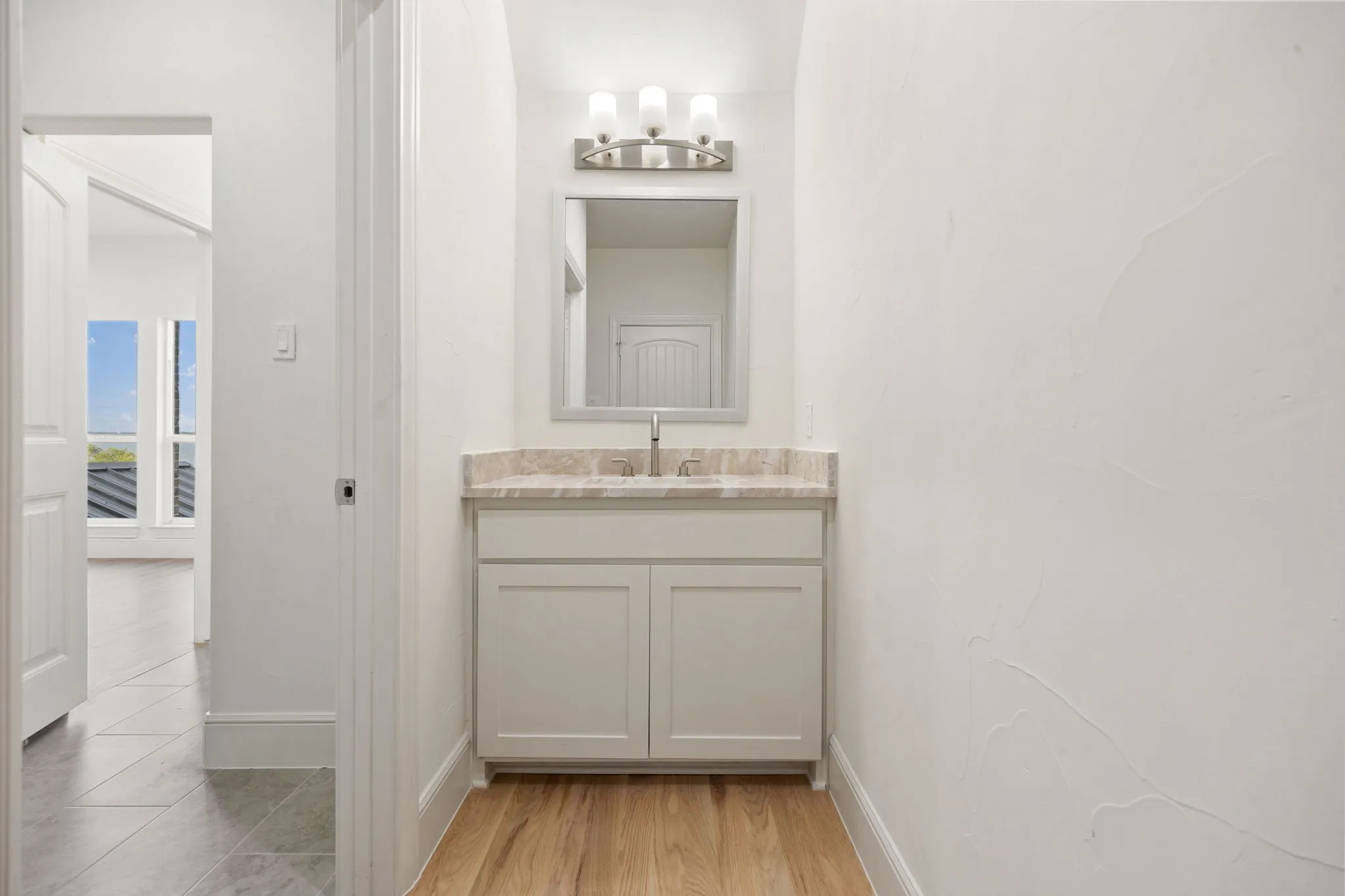 Vanity with a light-toned countertop, undermount sink, and brushed nickel faucet