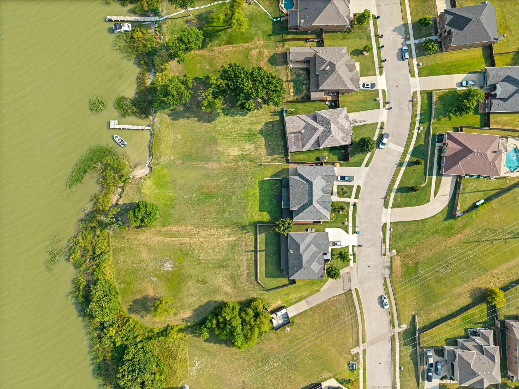 Aerial view showcasing this residential property's generous lot with mature landscaping, manicured lawn areas, and established trees