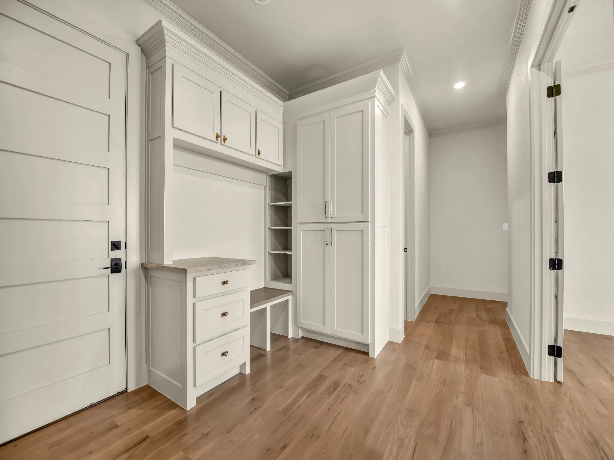 Built-in cabinetry with a stone countertop, hardwood flooring, recessed lighting, and crown molding