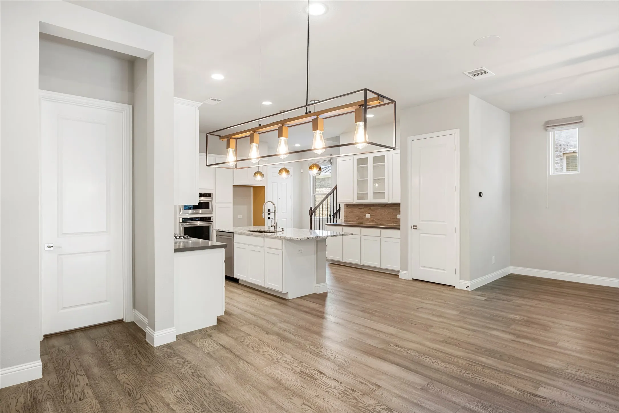 Open-concept living area featuring wood-finish flooring throughout