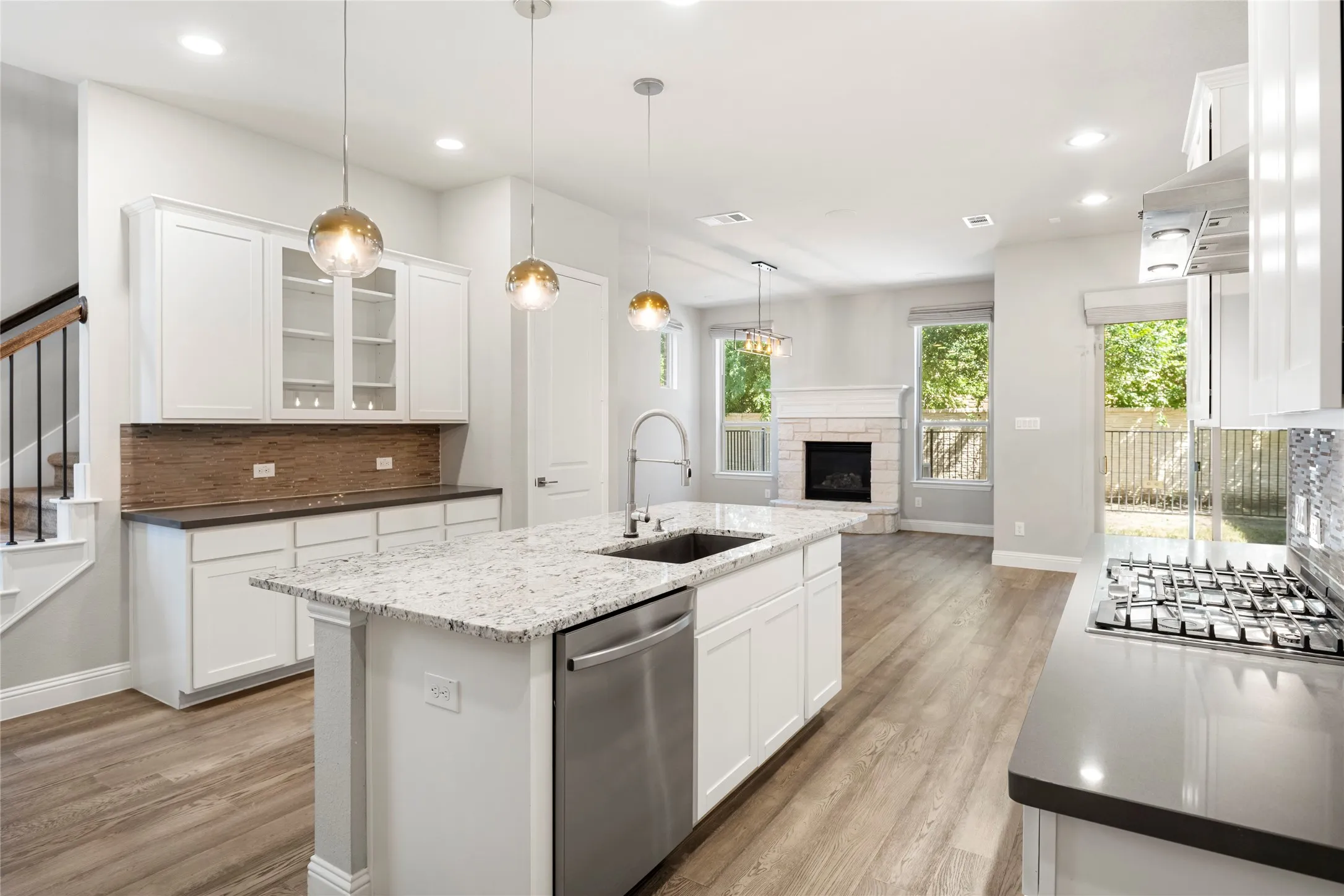Open-concept kitchen and living area featuring a central island with a granite countertop and undermount sink