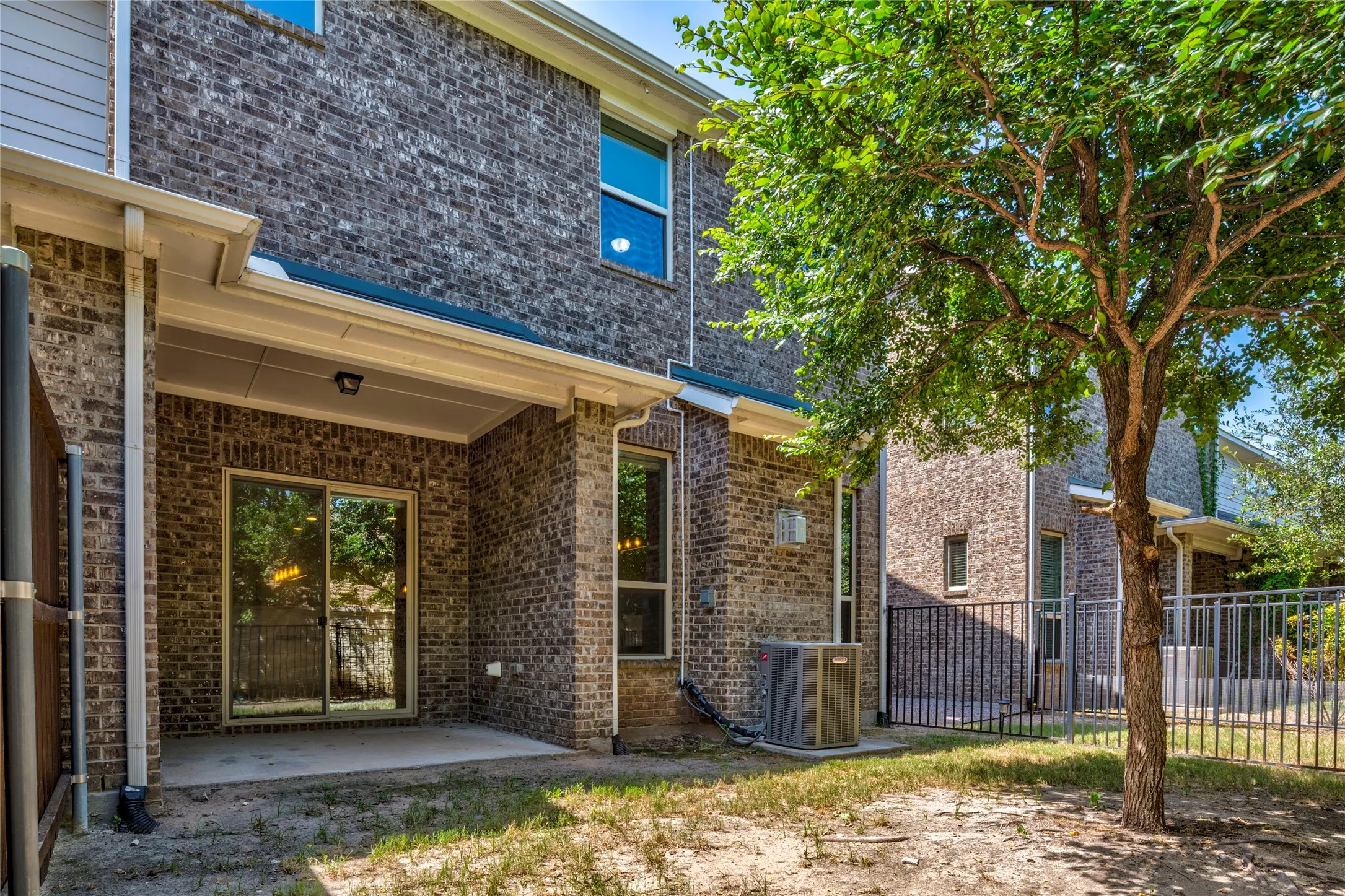 Brick exterior with a covered patio and sliding glass door access