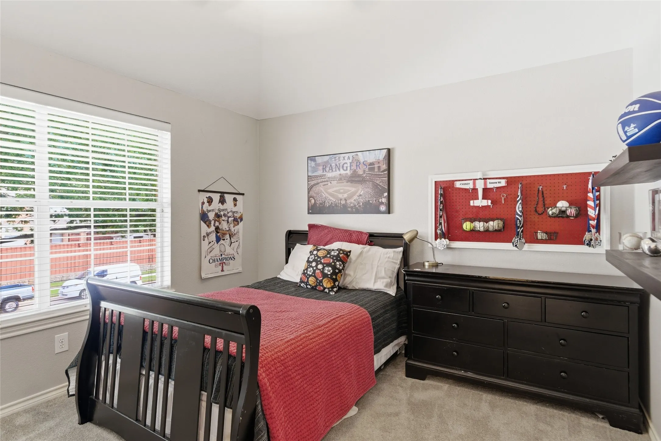 Carpeted room featuring a large window with blinds, light gray walls, and a vaulted ceiling