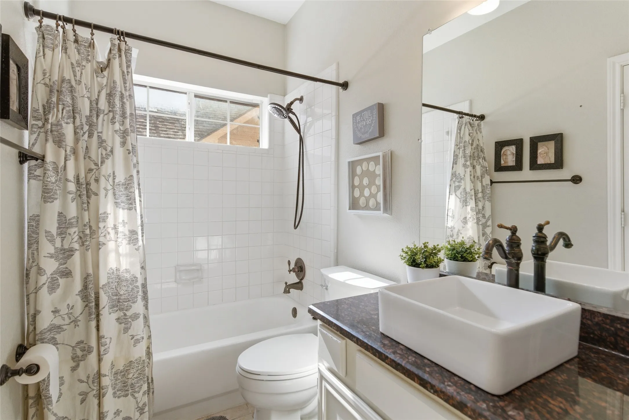 Bathroom vanity with a rectangular vessel sink, oil-rubbed bronze fixtures, and a dark stone countertop