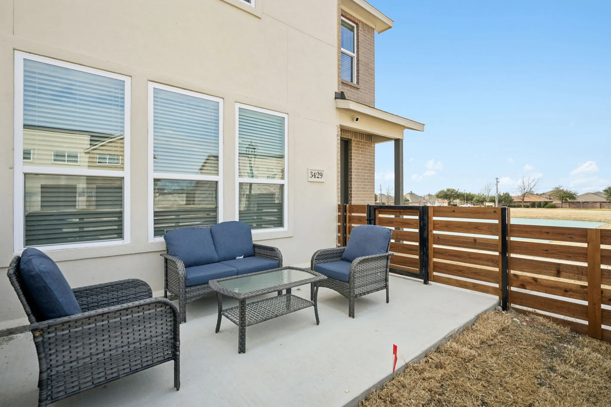 Concrete patio featuring a horizontal slat privacy fence