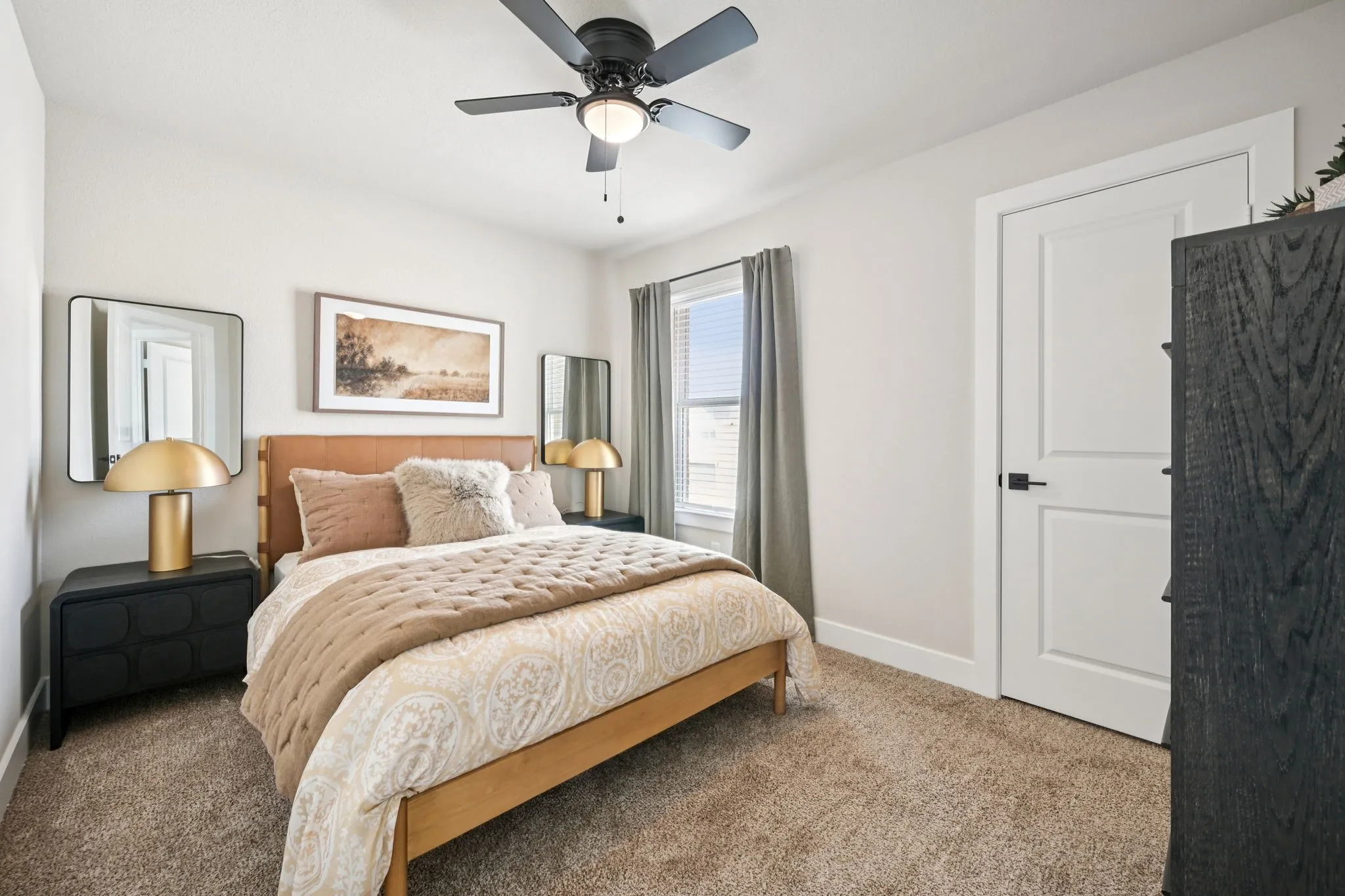 Carpeted bedroom featuring a ceiling fan with integrated lighting, a window with blinds and drapes, a white door with dark hardware, and a leather-look headboard