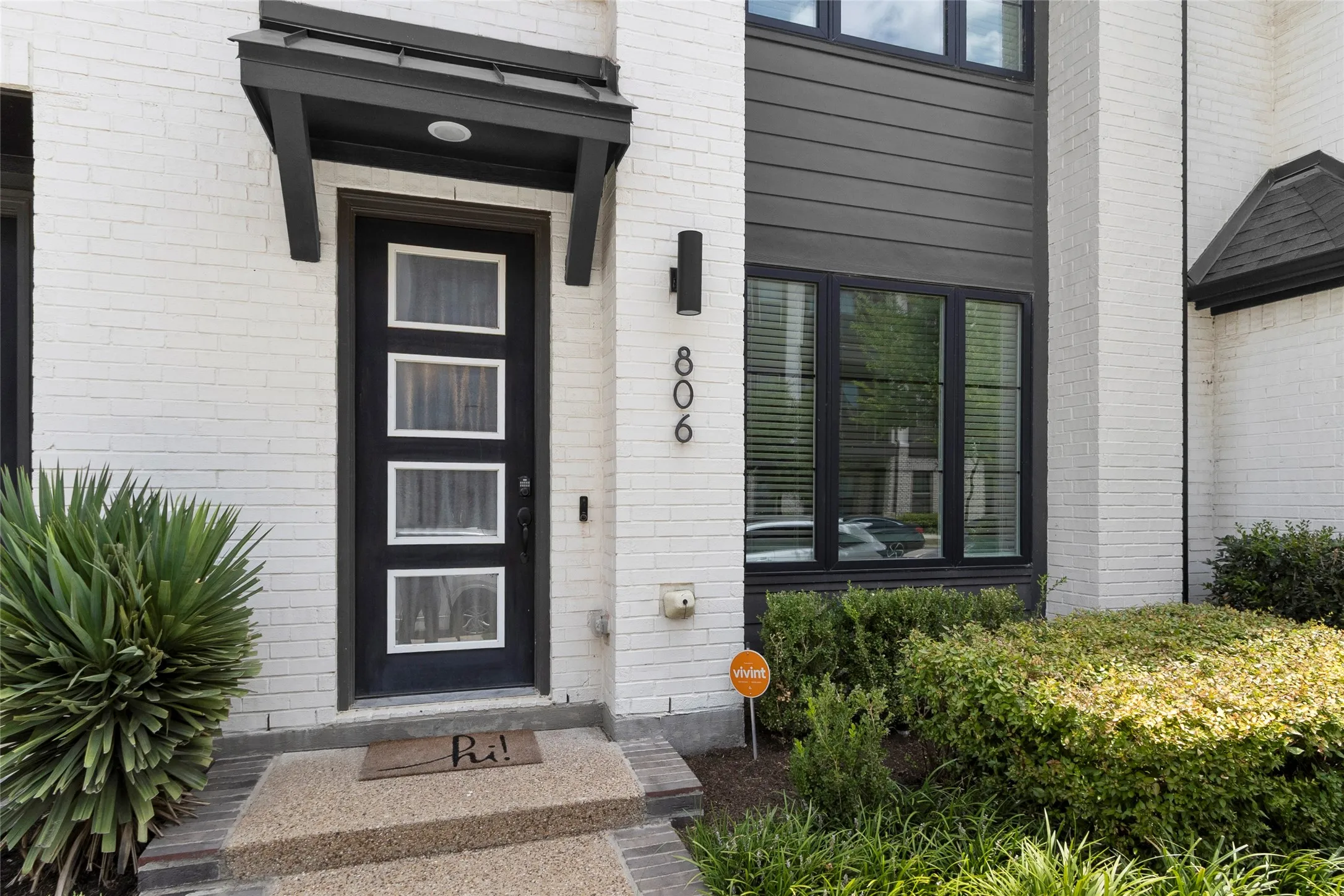 Modern exterior featuring white brick and dark horizontal siding